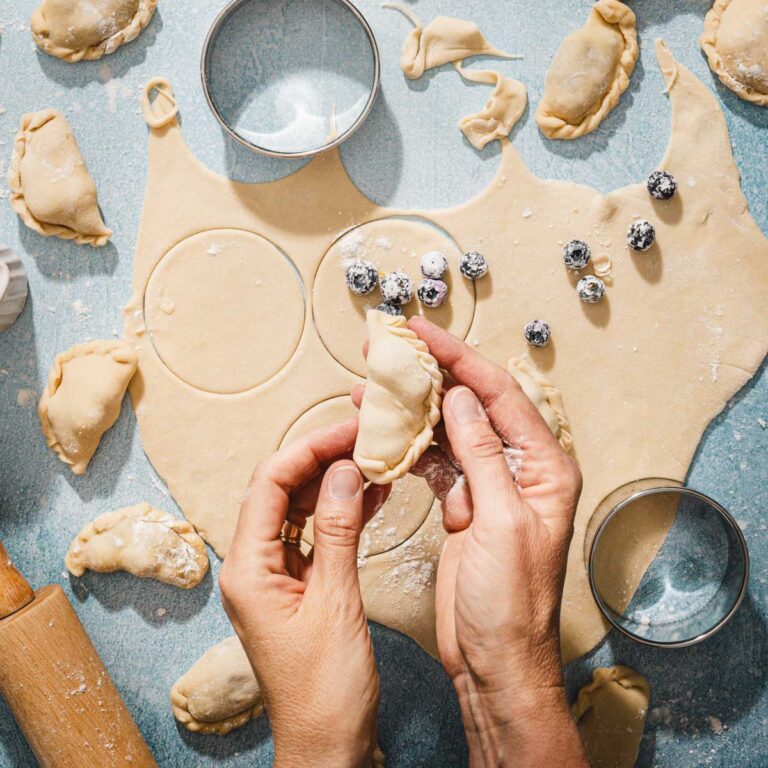 hands in frame holding pierogi