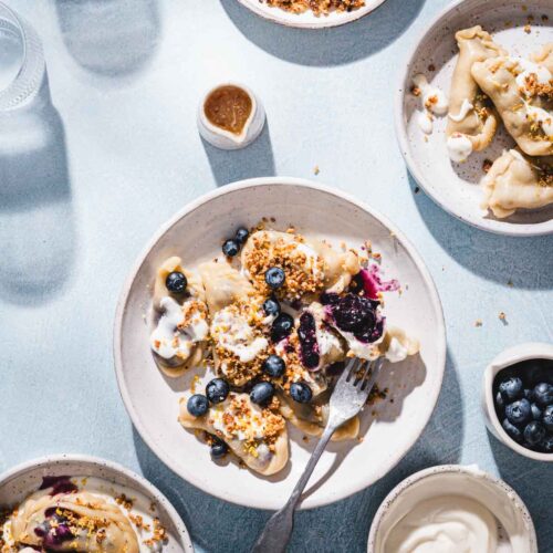pierogi dressed with cream, breadcrumbs on serving plates