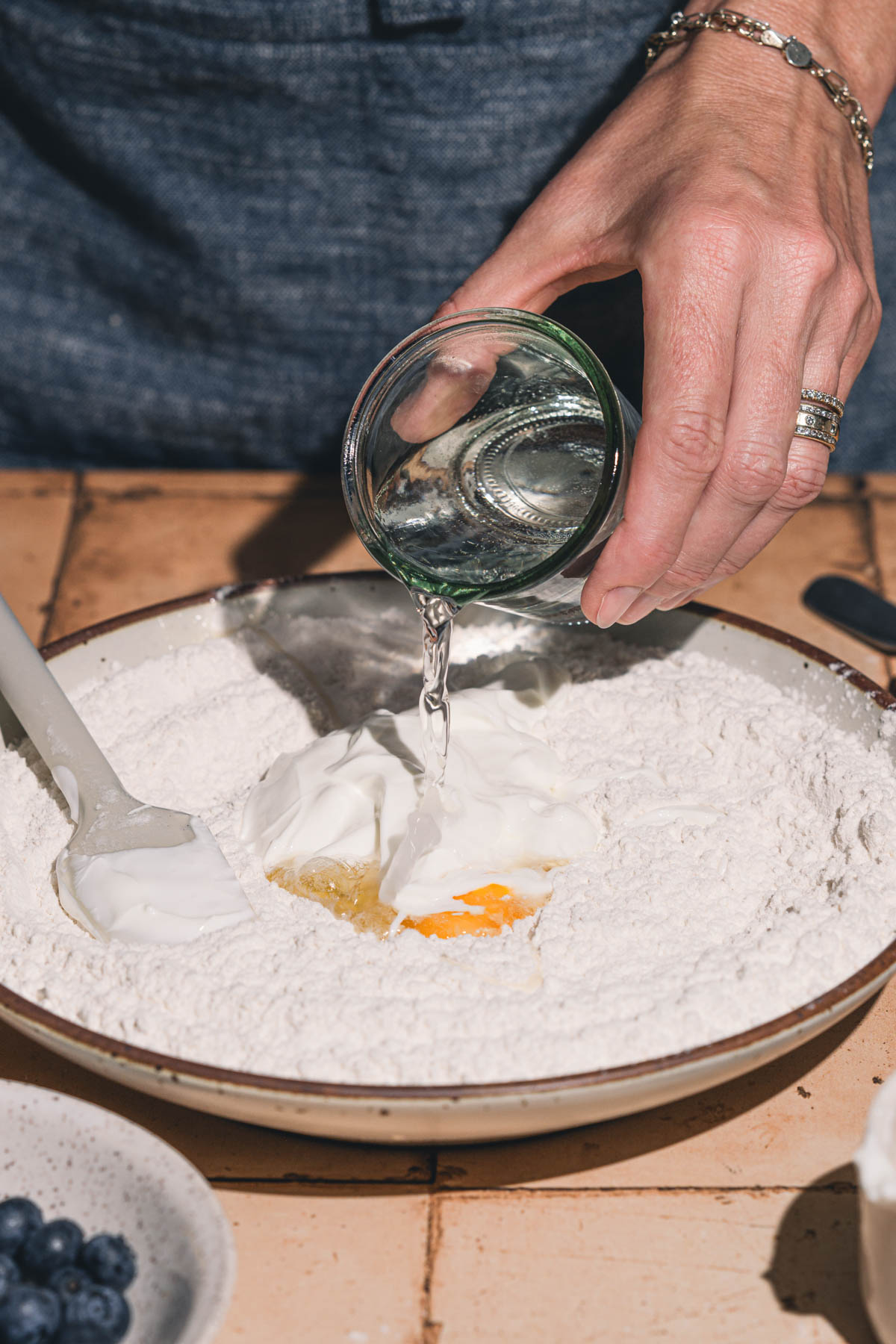 hands in frmae pouring water over the dough