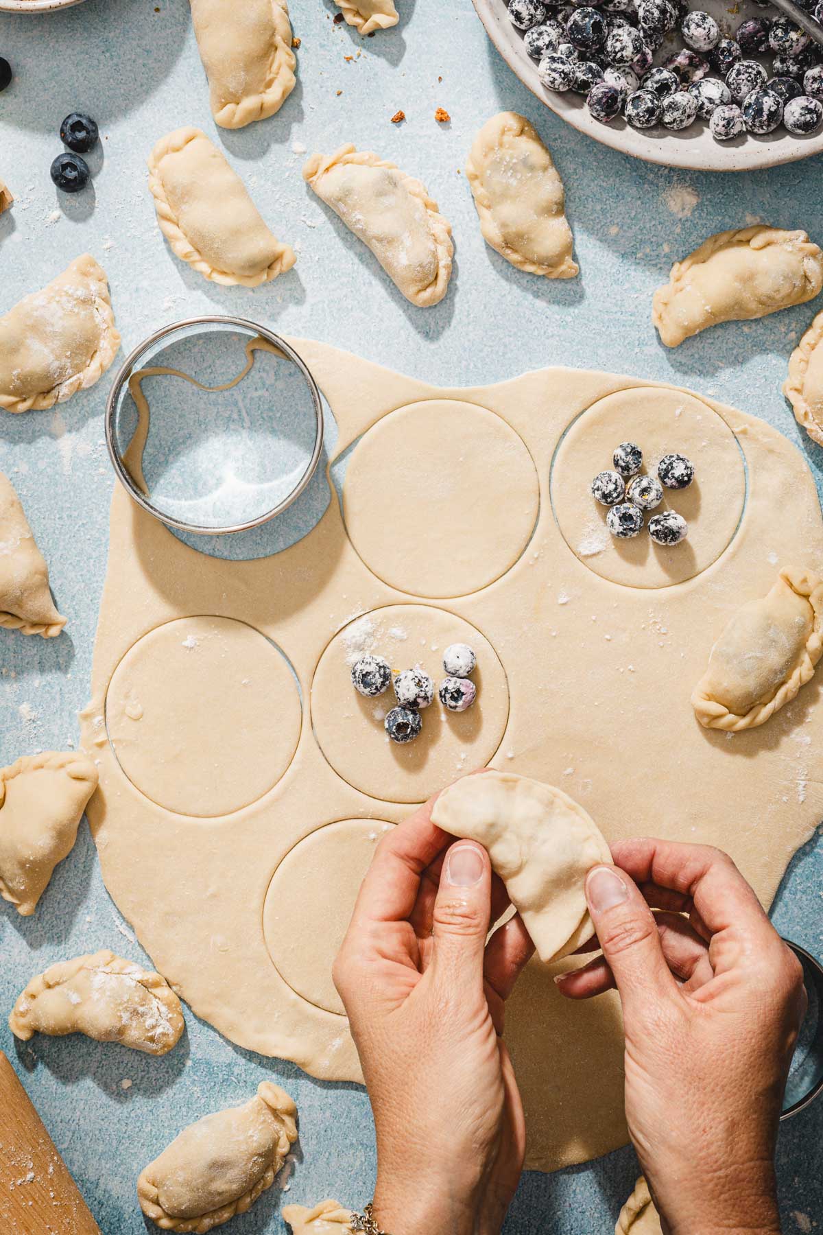 hands in frame pinching pierogi