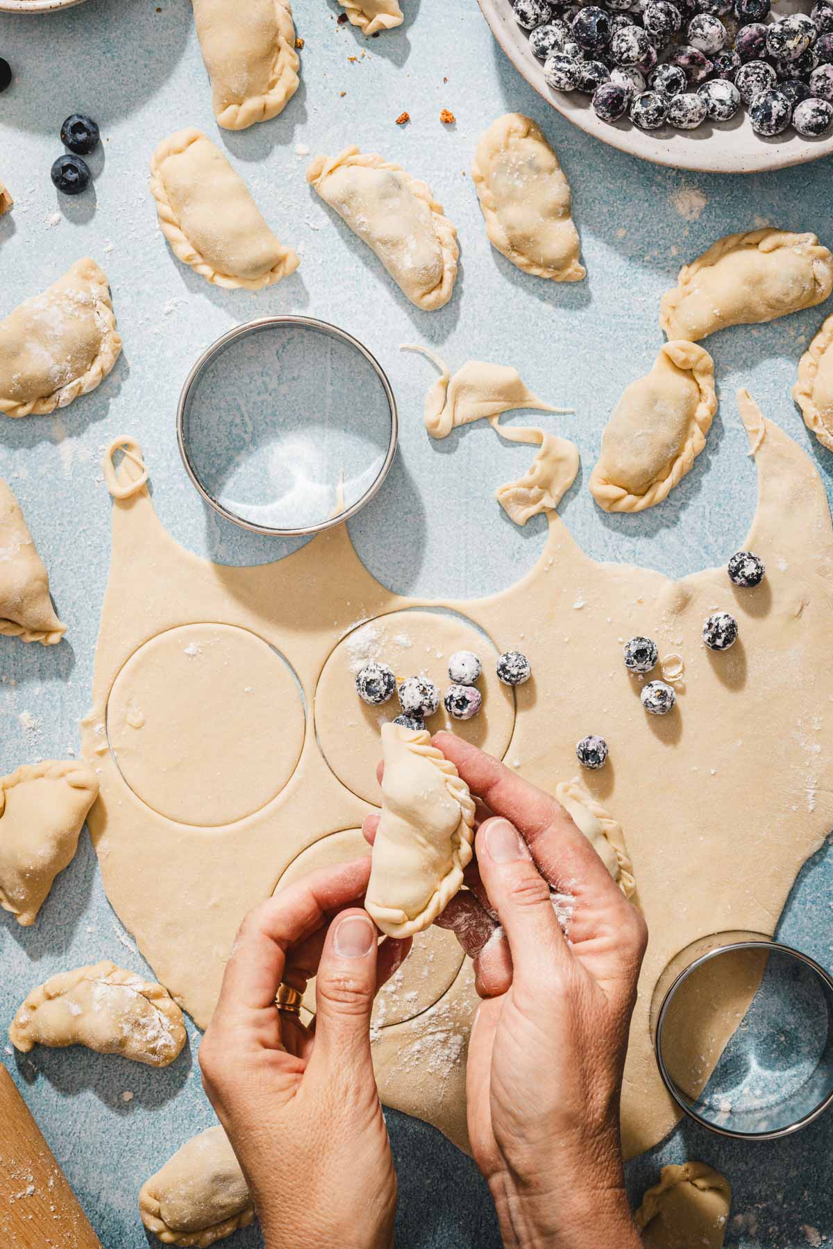 hands in frame holding pierogi
