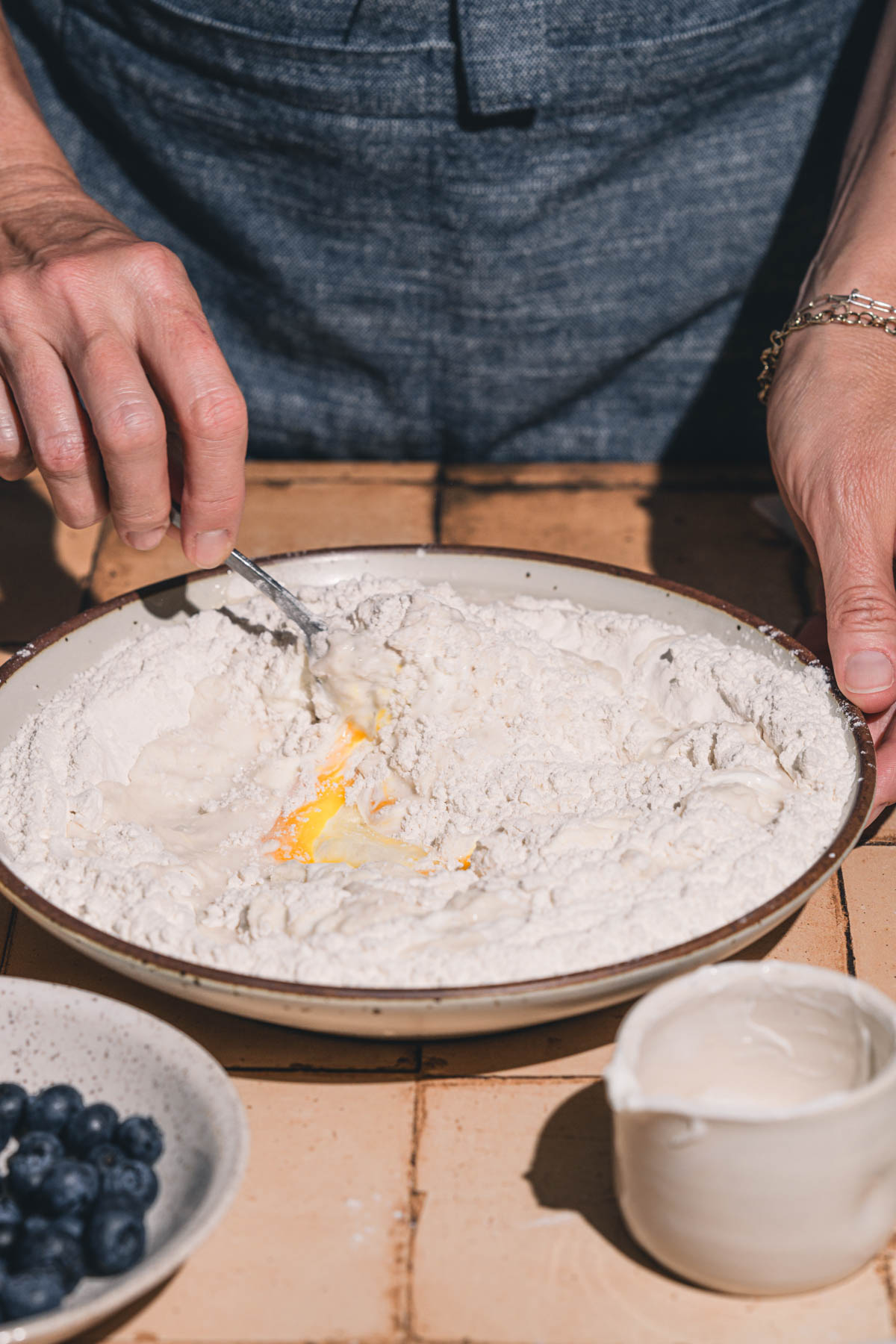 hands in frmae holding a fork and mixing the dough