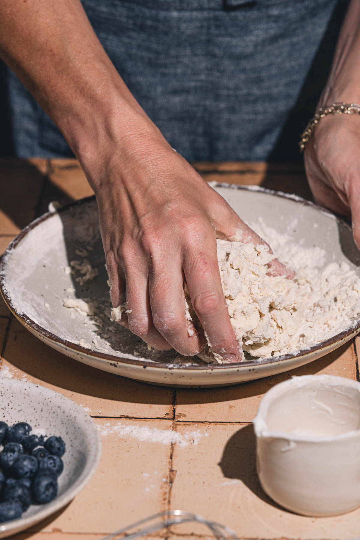 hands in frame kneading the dough