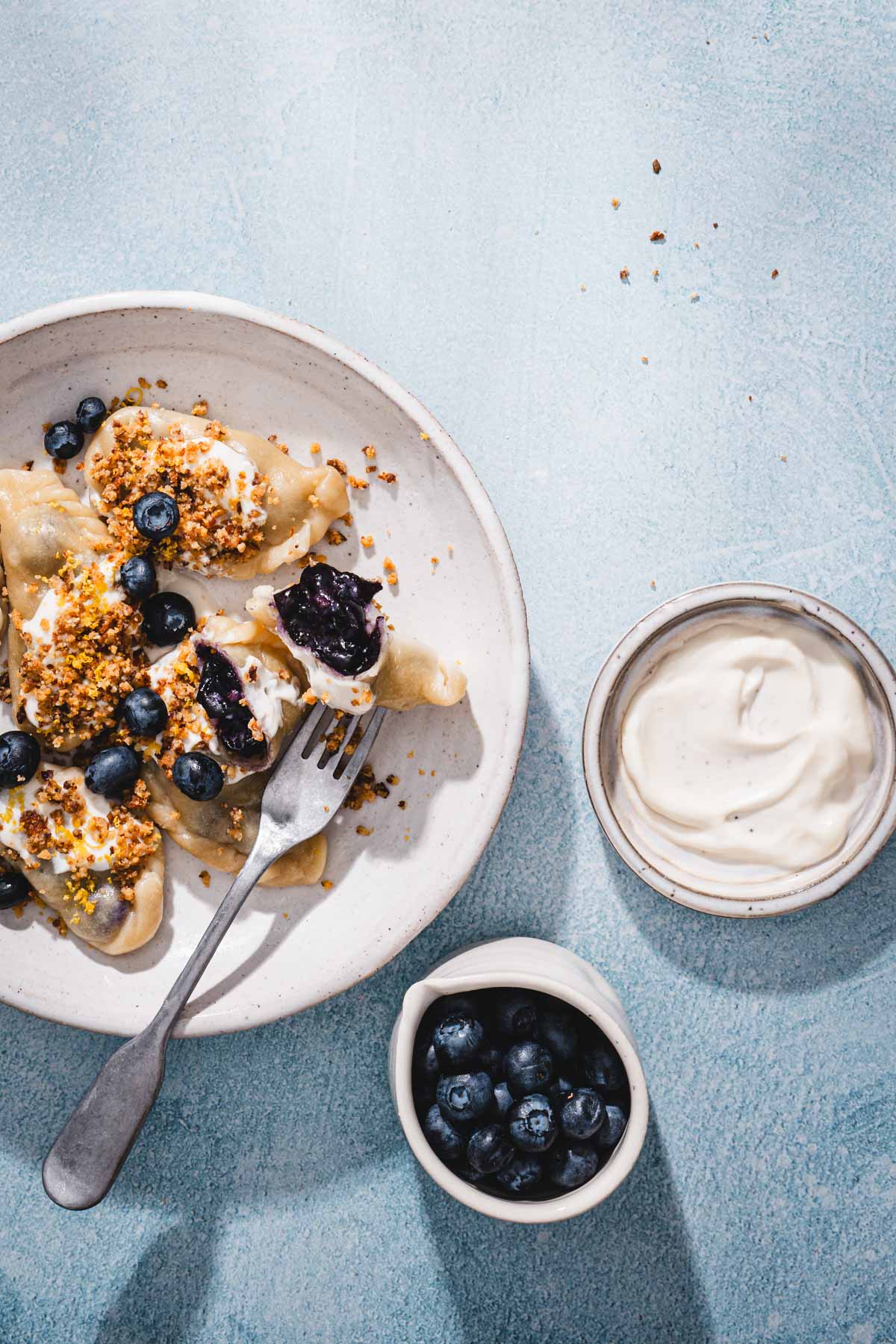 plate with pierogi, cream, crumbs