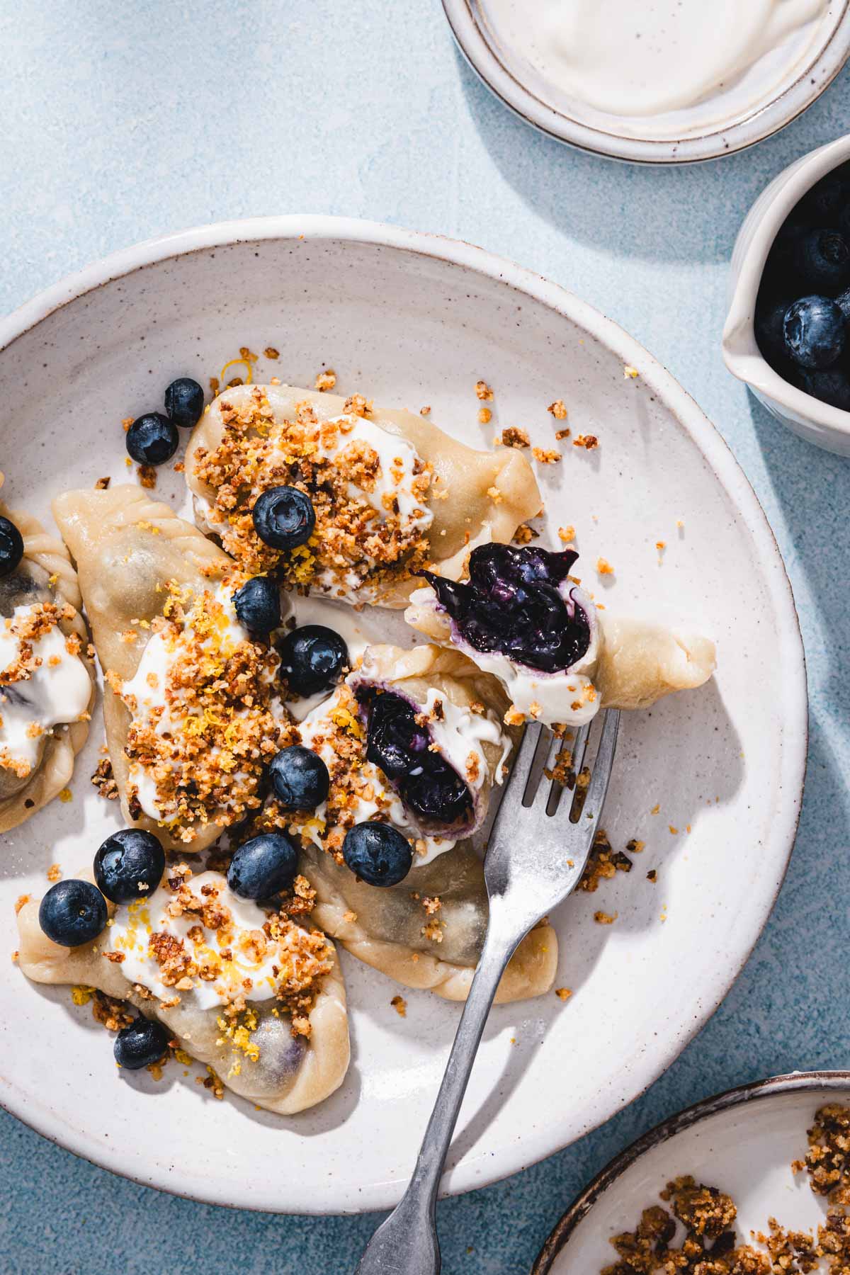 plate with pierogi, cream, crumbs