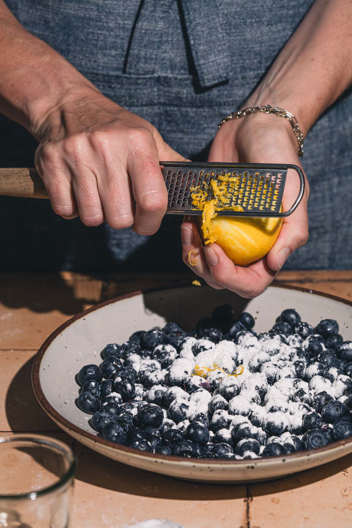 hands in frame holding zester and a lemon