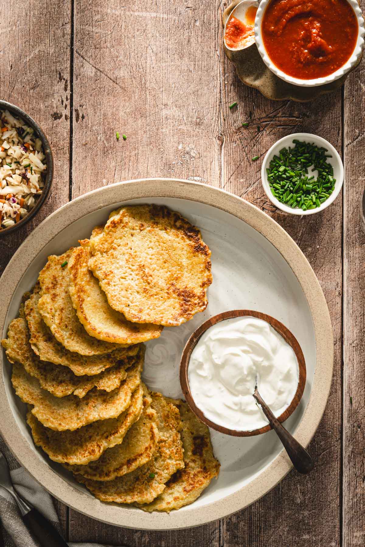 potatoes pancakes styled on a serving platter; small bowls and dishes with various garnishes