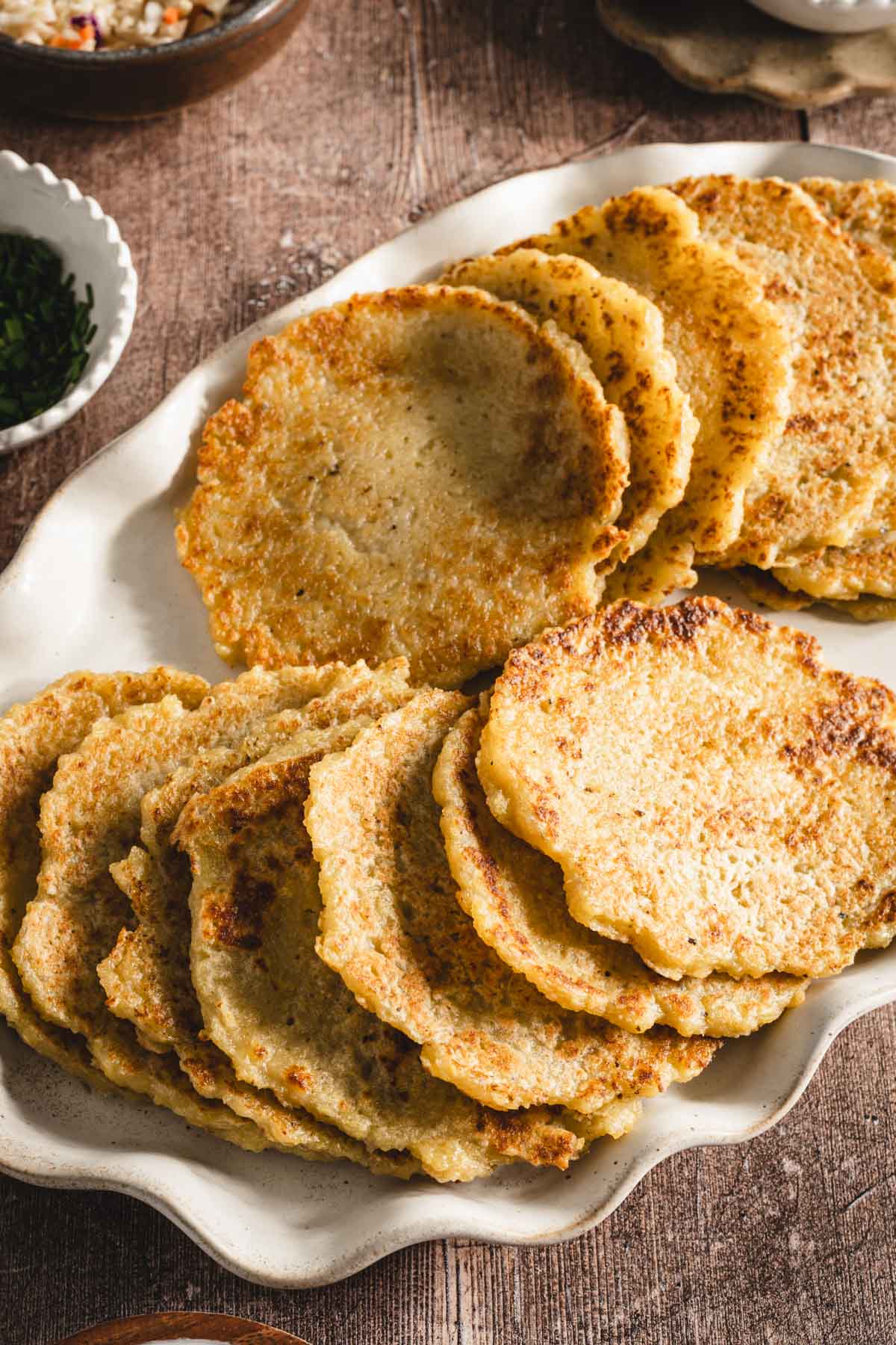 potatoes pancakes styled on a serving platter; small bowls and dishes with various garnishes