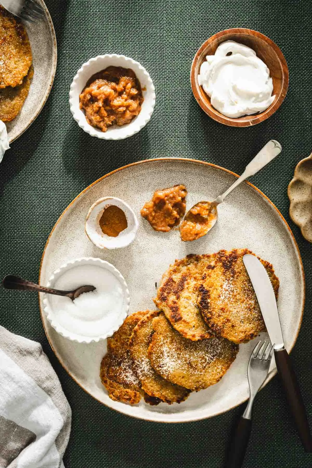 potatoes pancakes styled on a serving platter; small bowls and dishes with various garnishes