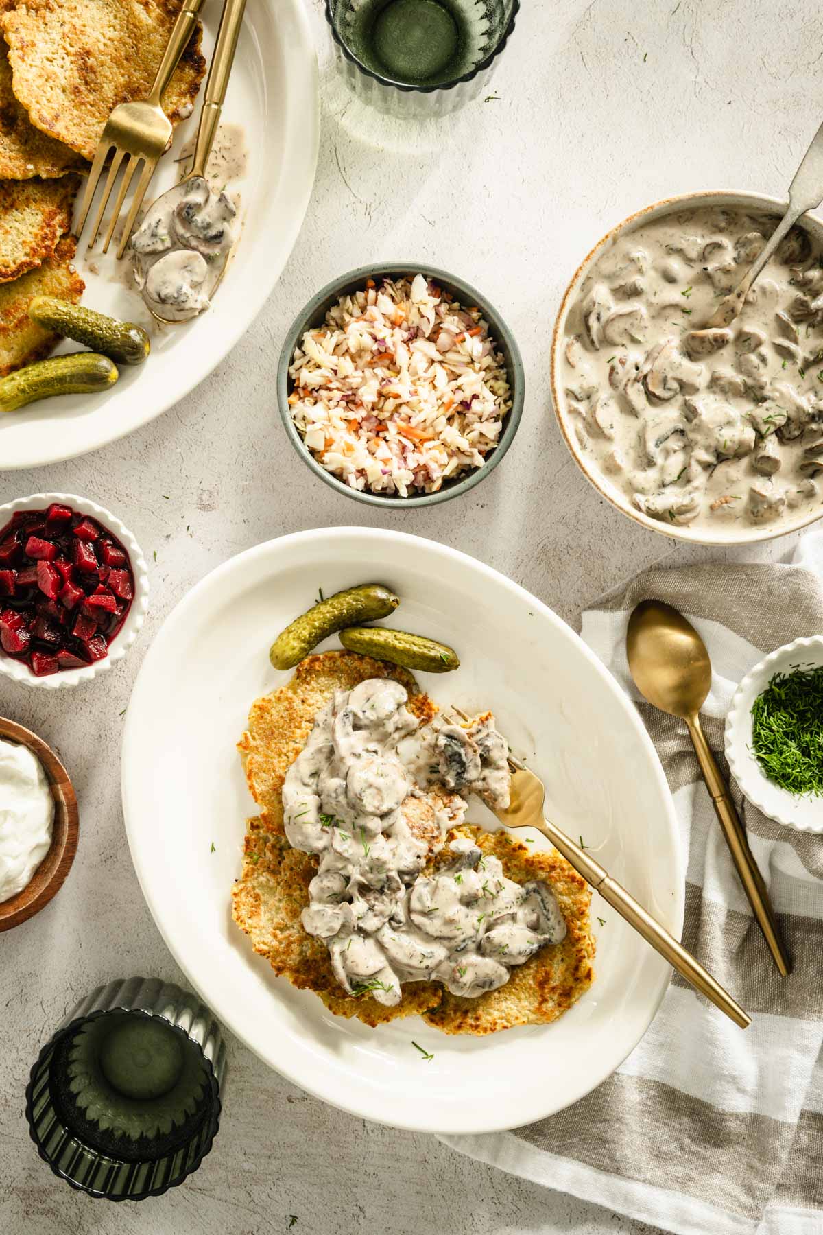 potatoes pancakes styled on a serving platter; small bowls and dishes with various garnishes