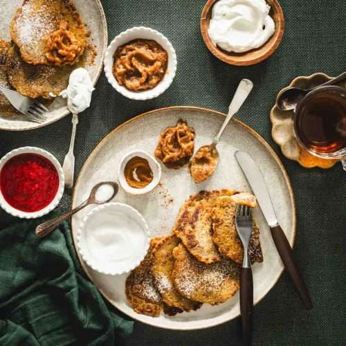 potatoes pancakes styled on a serving platter; small bowls and dishes with various garnishes