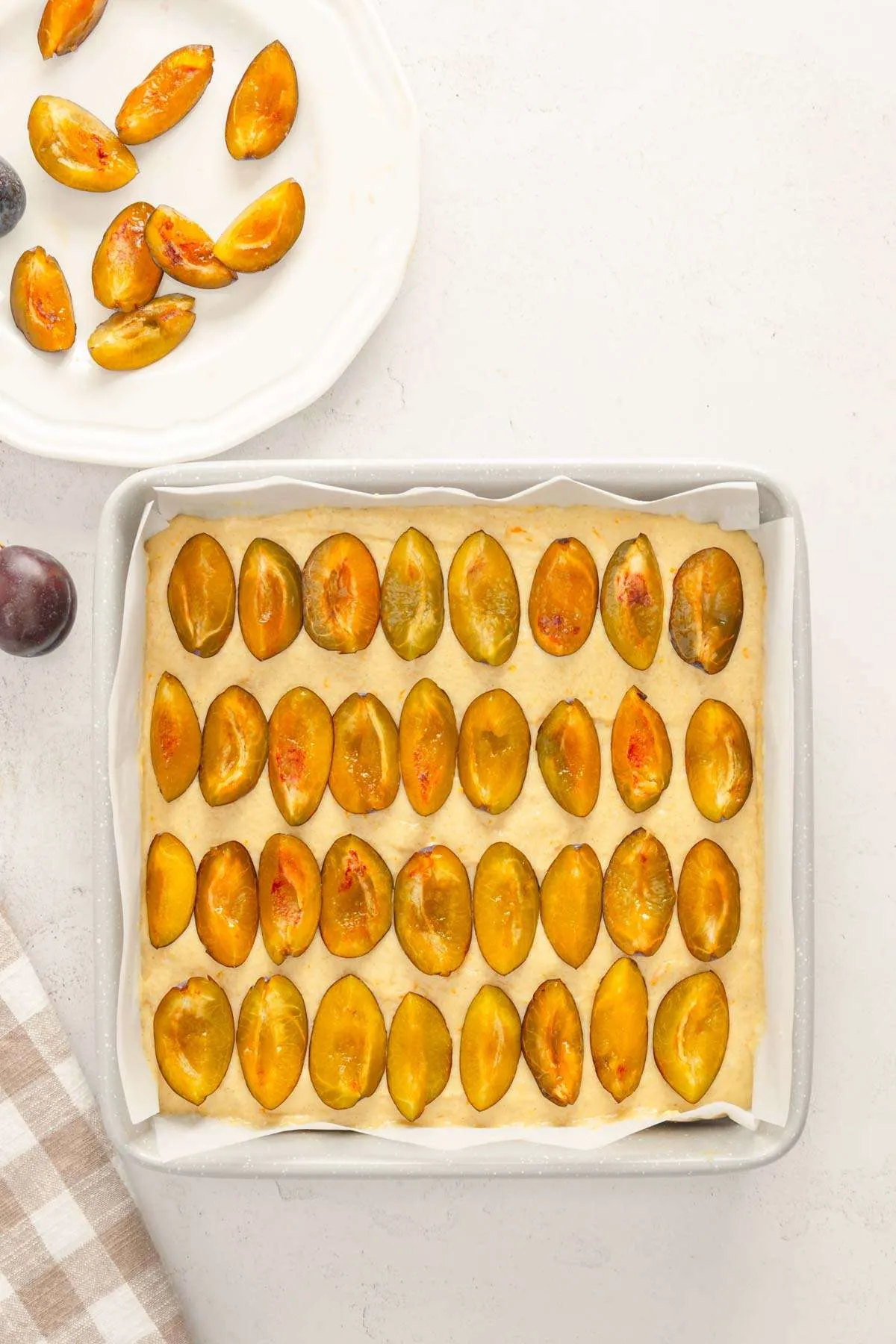 plums arranged on the batter
