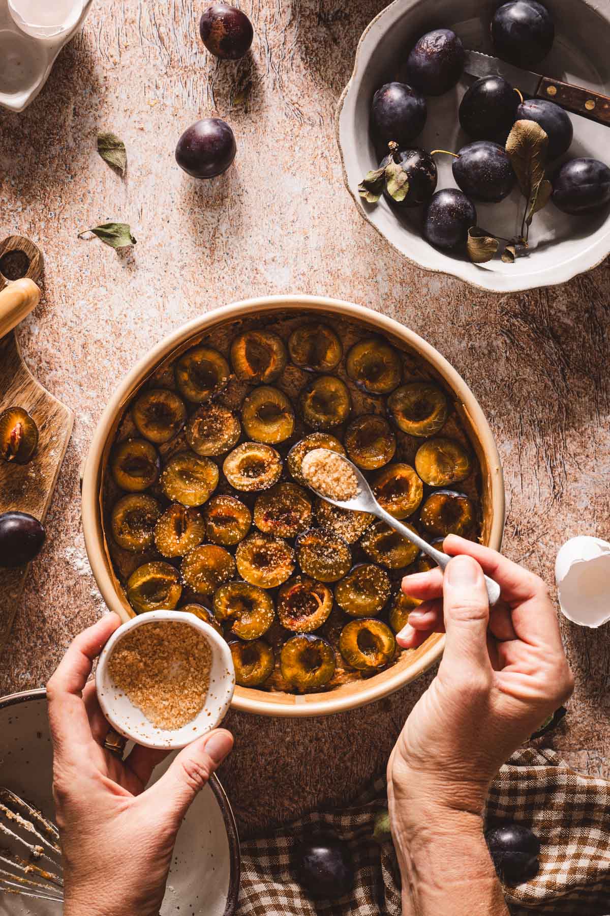 hands in frame applying layer of turbinado sugar