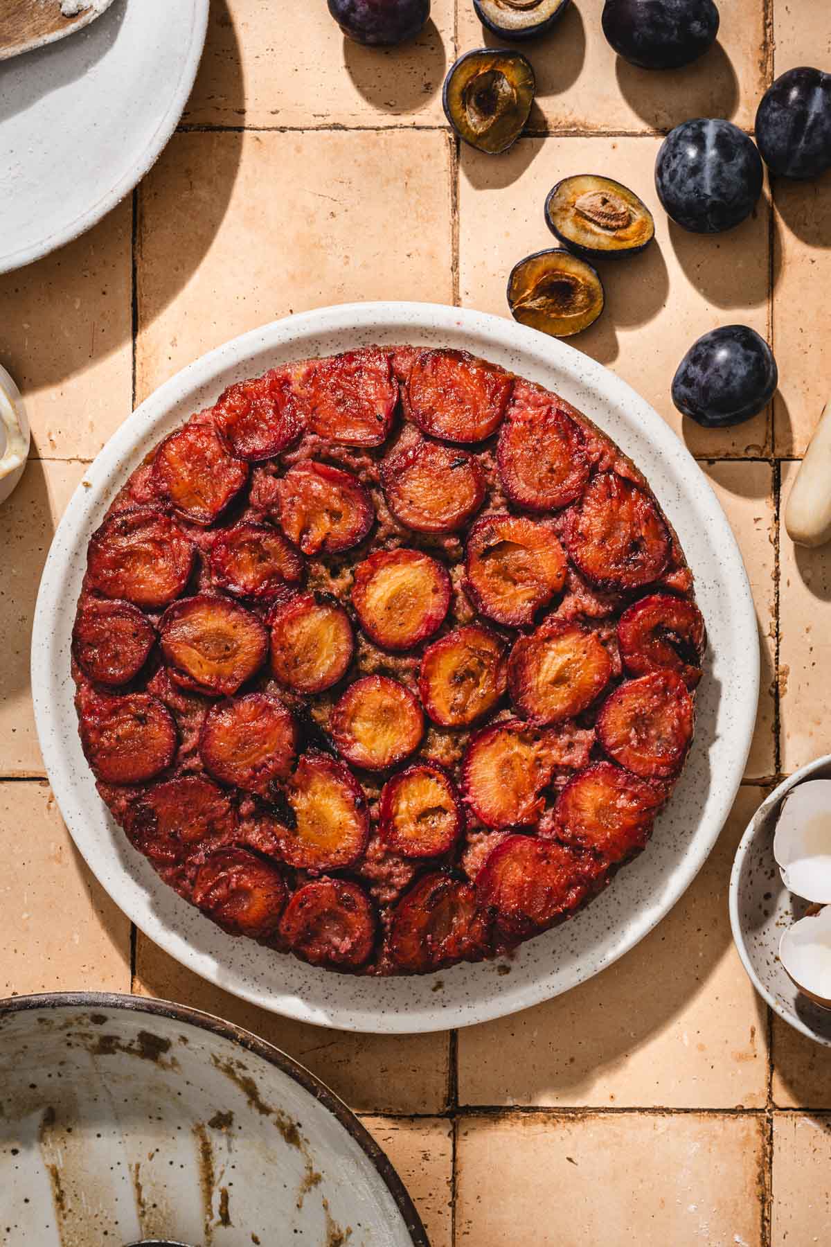 baked plum cake on a serving plate