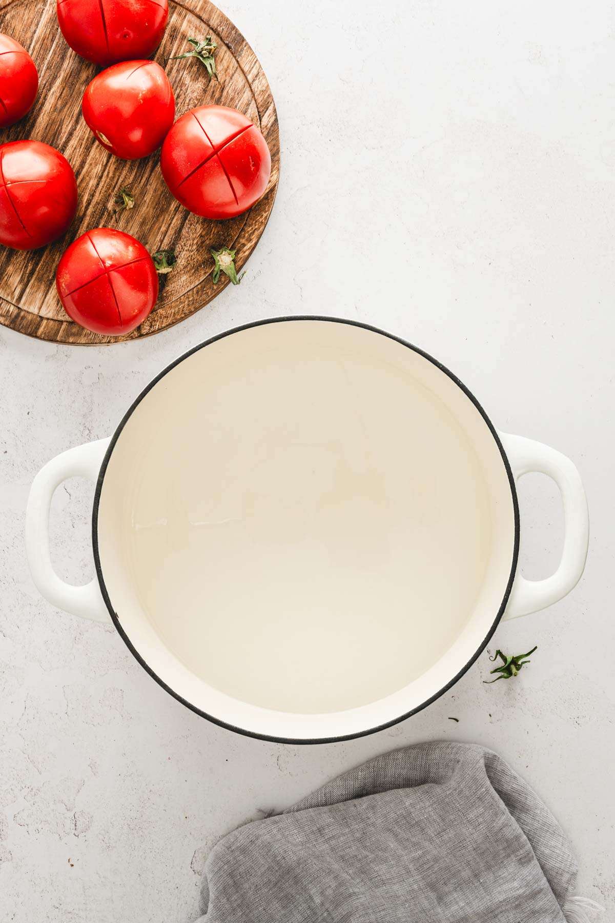 large stock pot filled with water, tomatoes on a cutting board