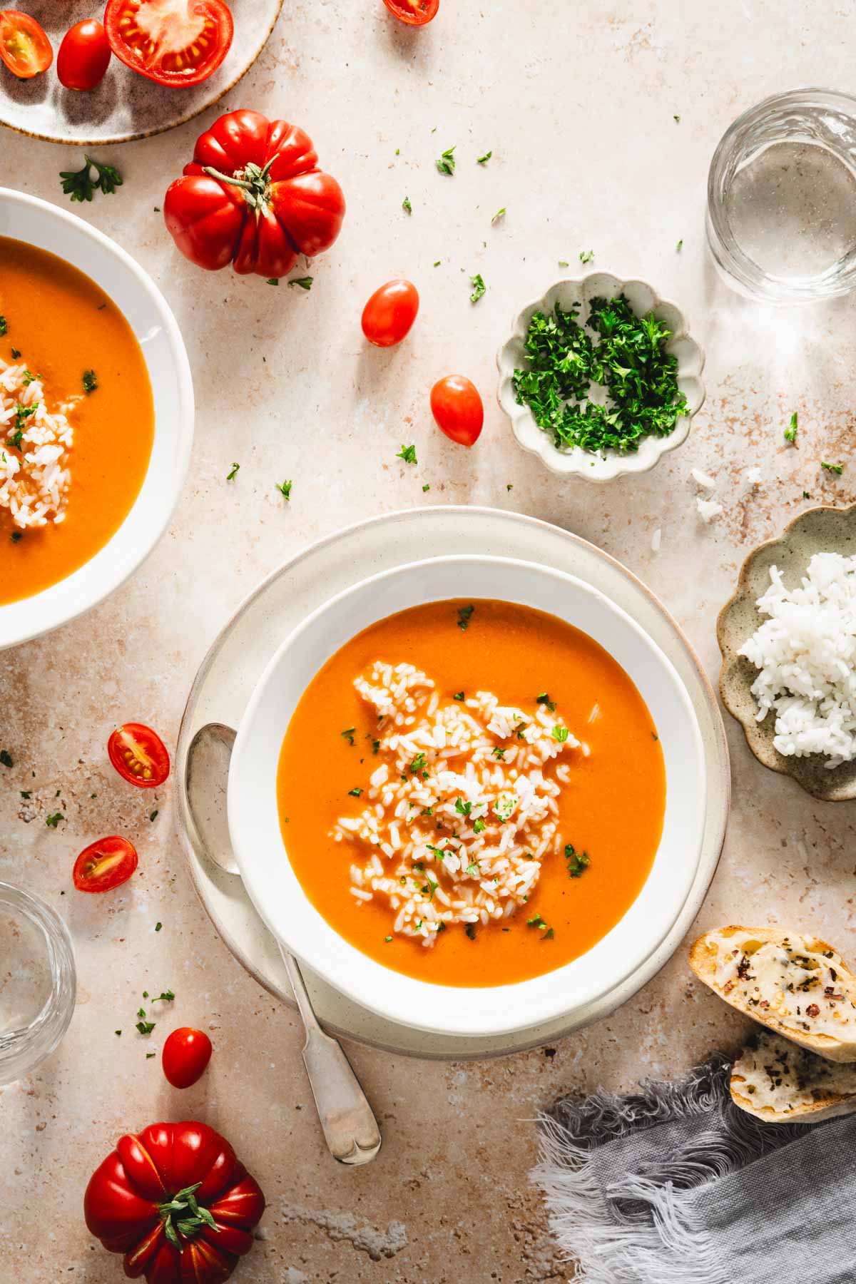 bowls with zupa pomidorowa, plate with rice, dish with parsley, cheesy toast