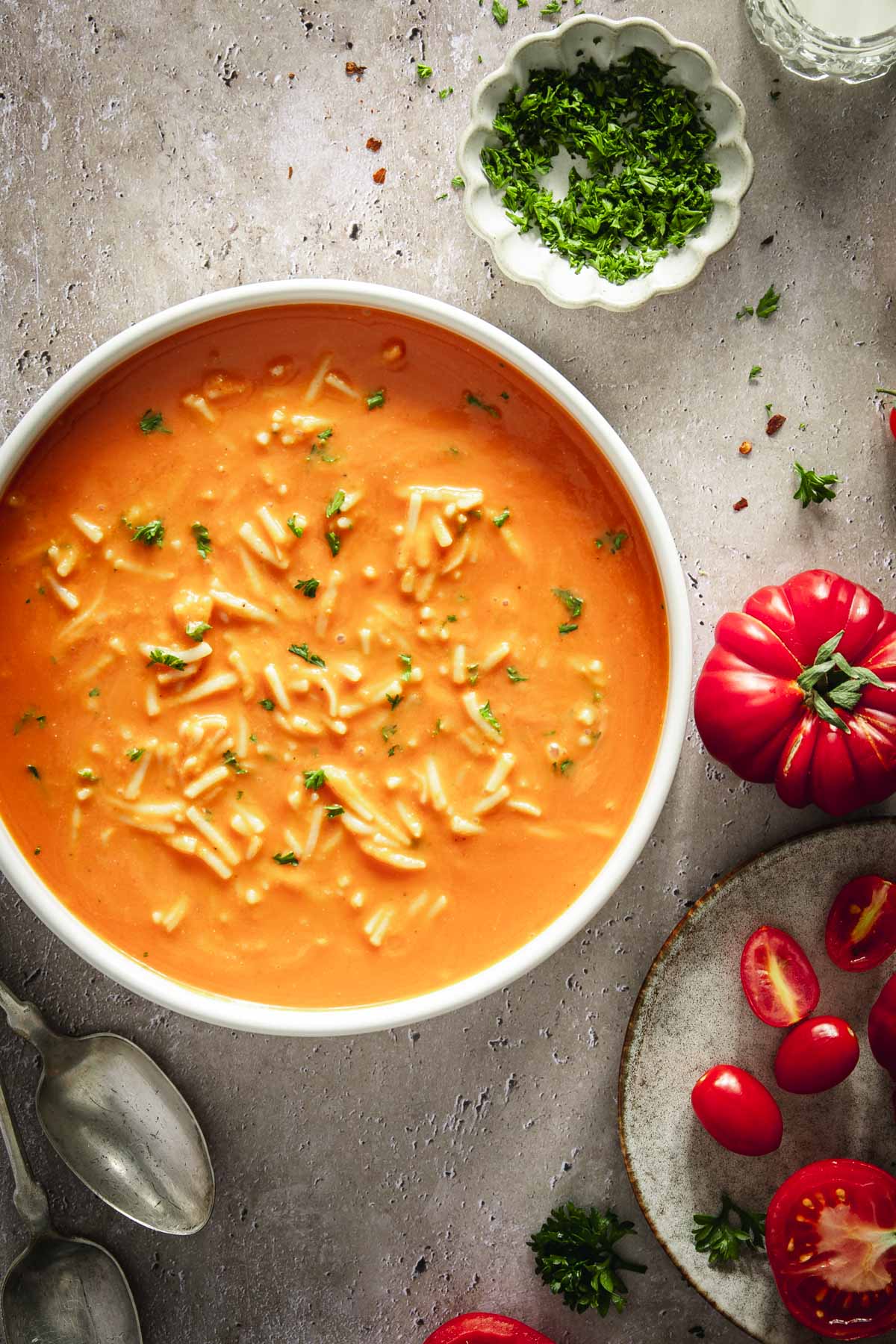 bowl with zupa pomidorowa, plate with tomatoes, dish with parsley