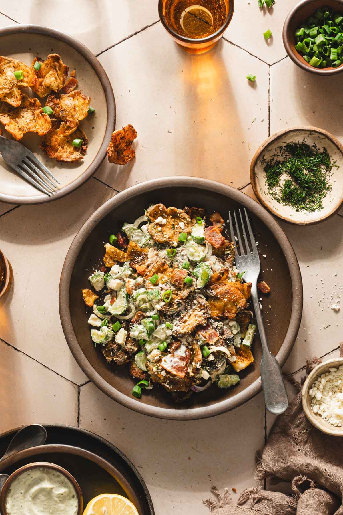 salad on a serving plate, small plates around, glass with water