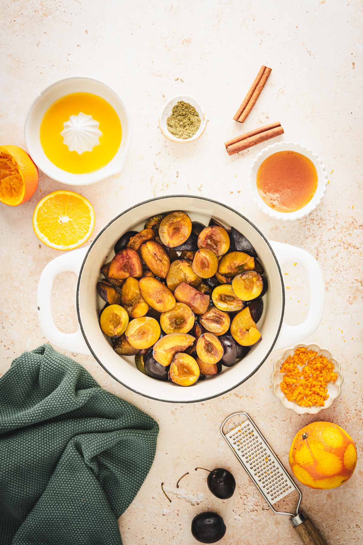 large pan with cut up plums, other ingredients to make powidla around