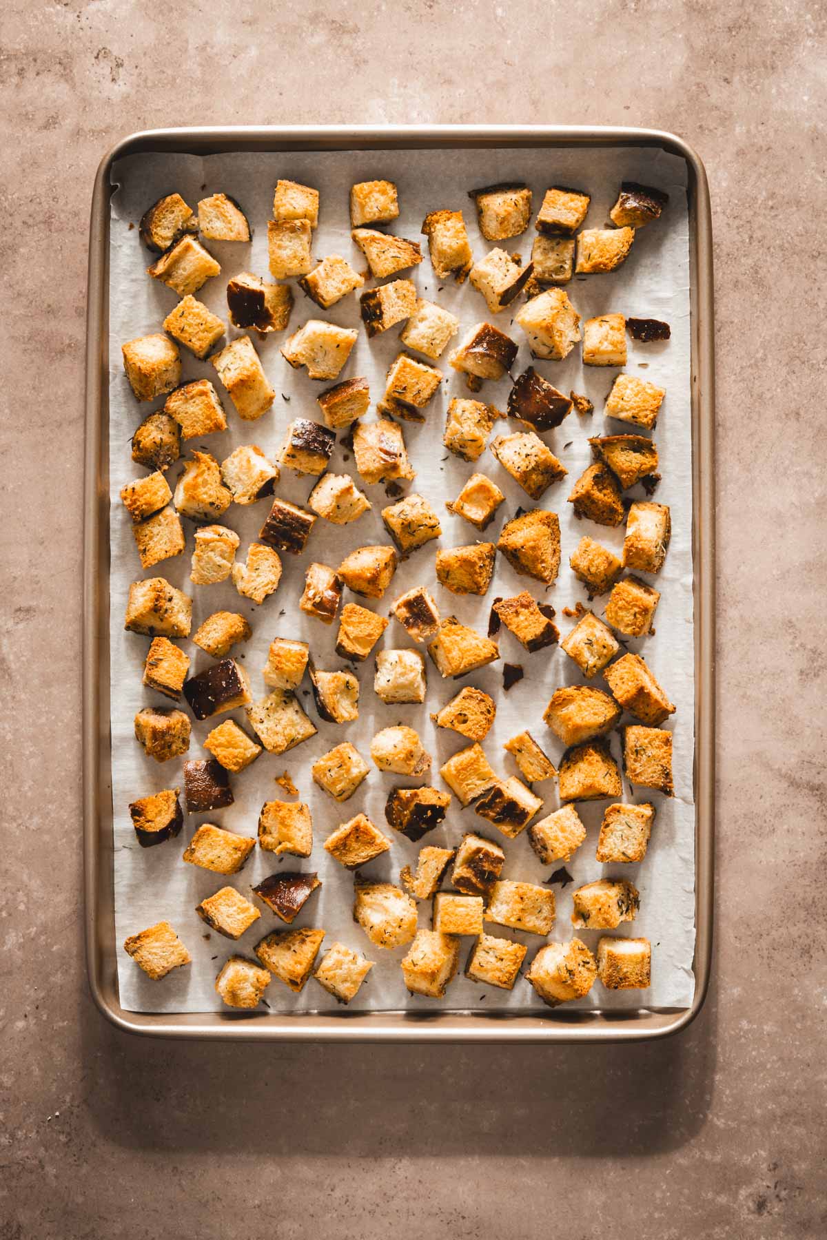 baked pretzel bun croutons on a baking sheet