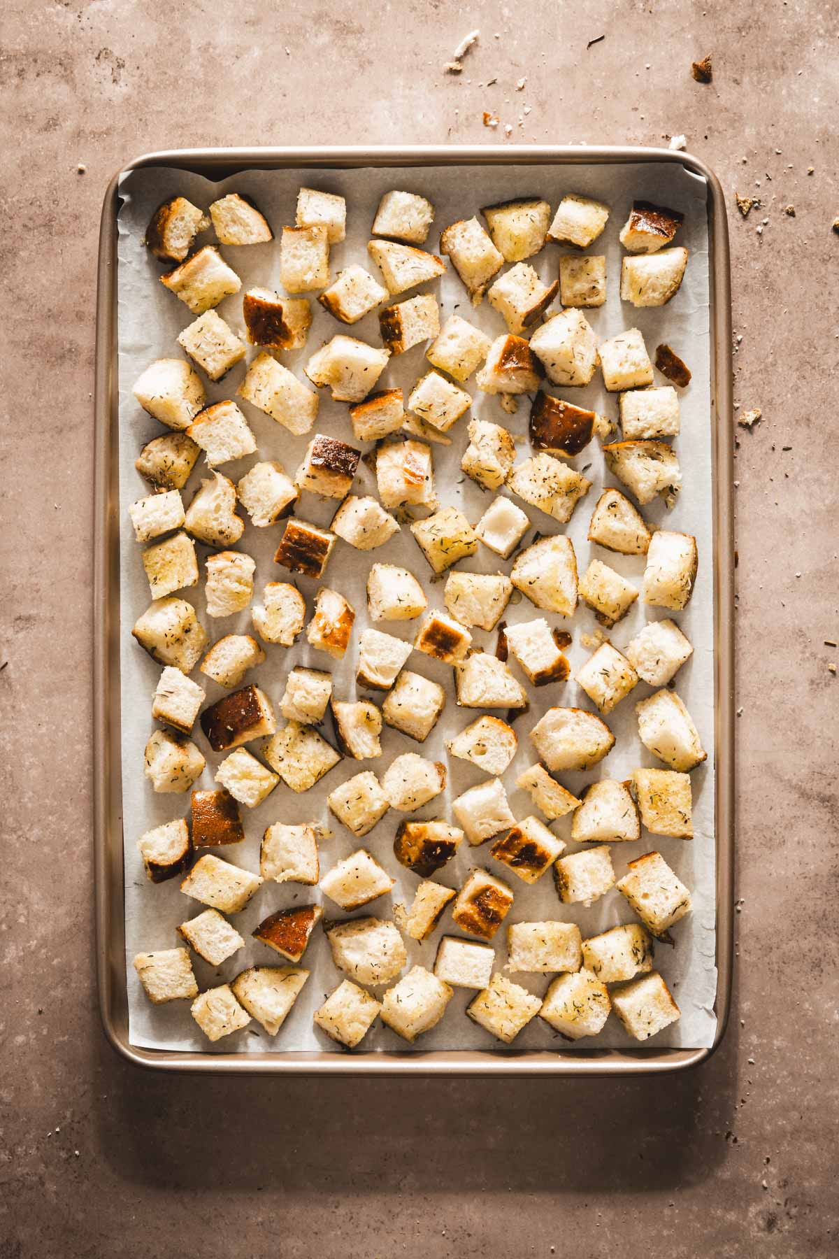 pretzel bun croutons on a baking sheet, ready to bake