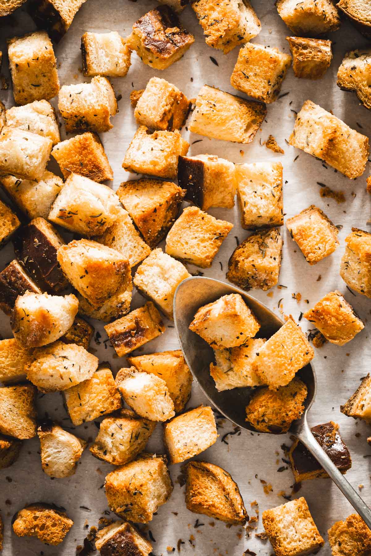 pretzel bun croutons on a baking sheet, spoon in frame