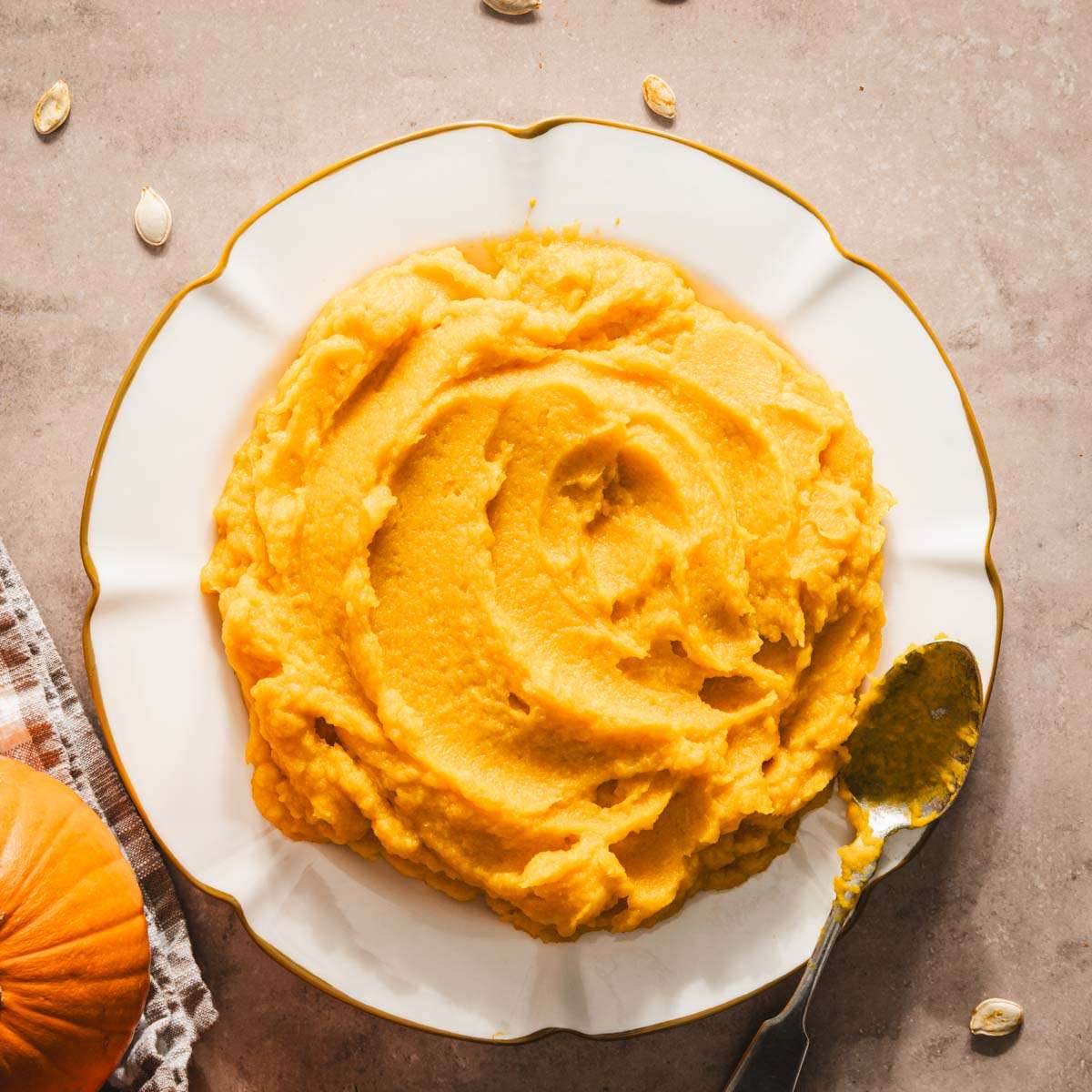 pumpkin puree on a plate, two pumpkins, spoon