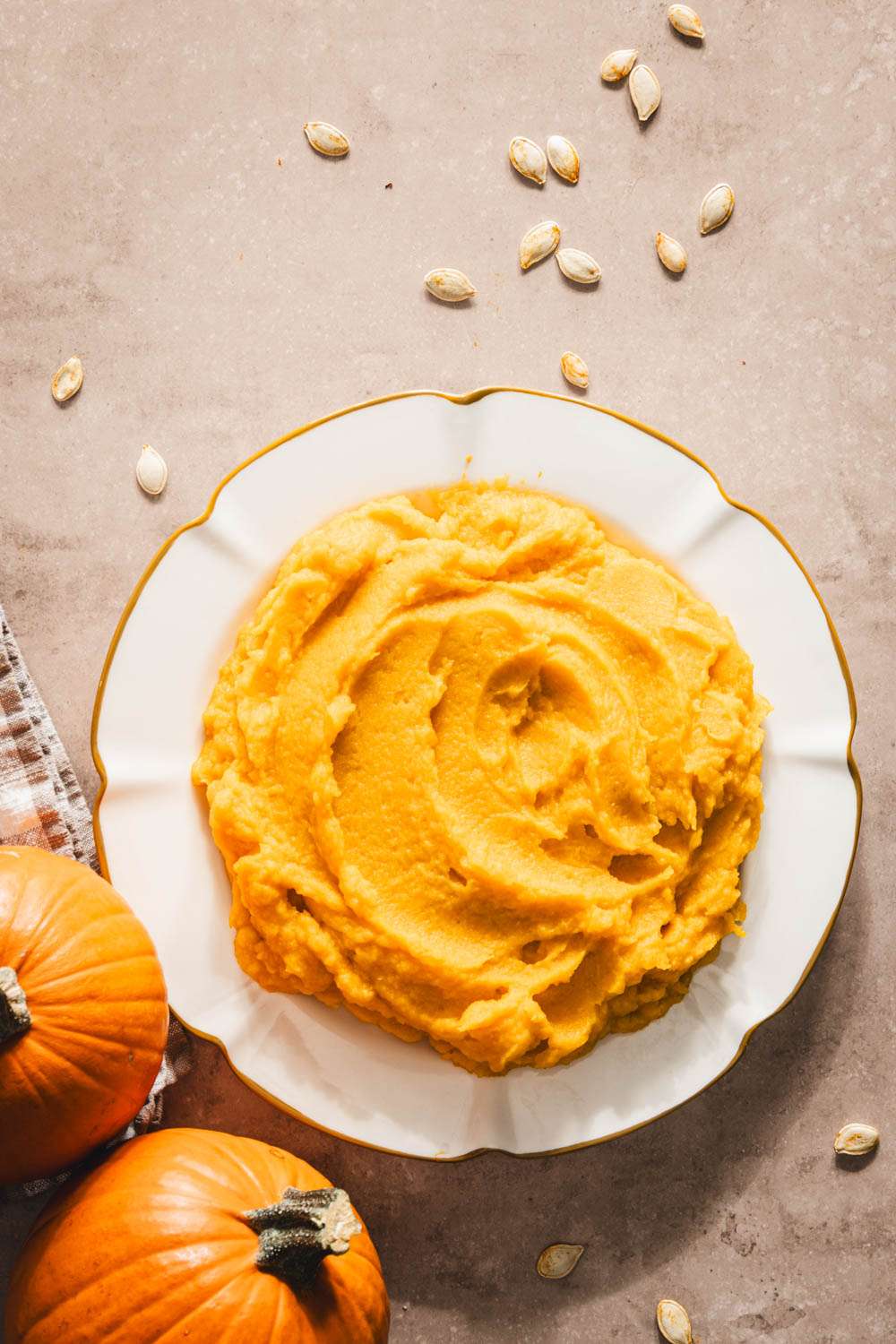 pumpkin puree on a plate, two pumpkins, spoon