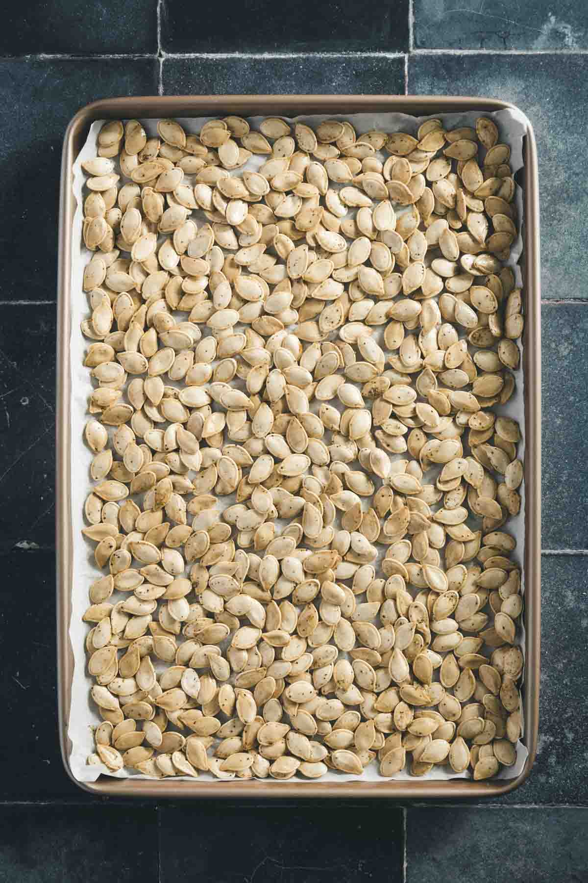 cooked pumpkin seeds on a baking sheet