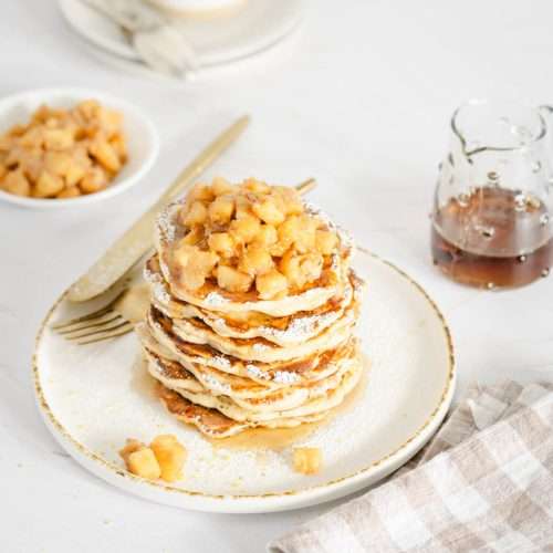 plate with racuchy stack topped with chopped apples