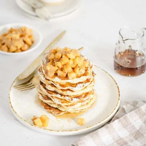 plate with racuchy stack topped with chopped apples