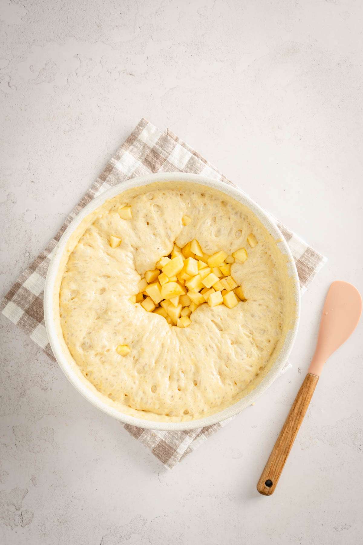 cut up apples added to the bowl with batter