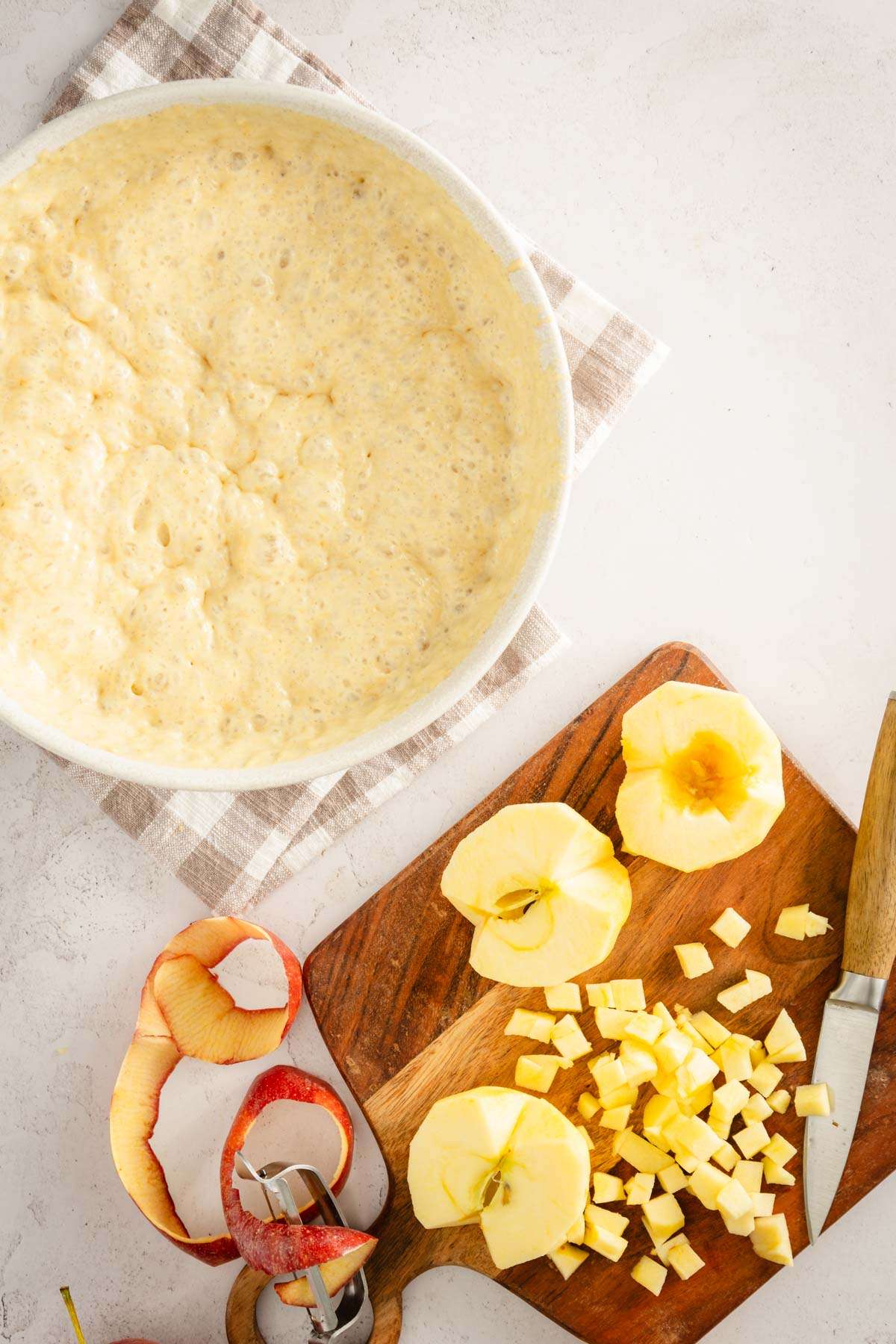 bowl with batter and cutting board with apples