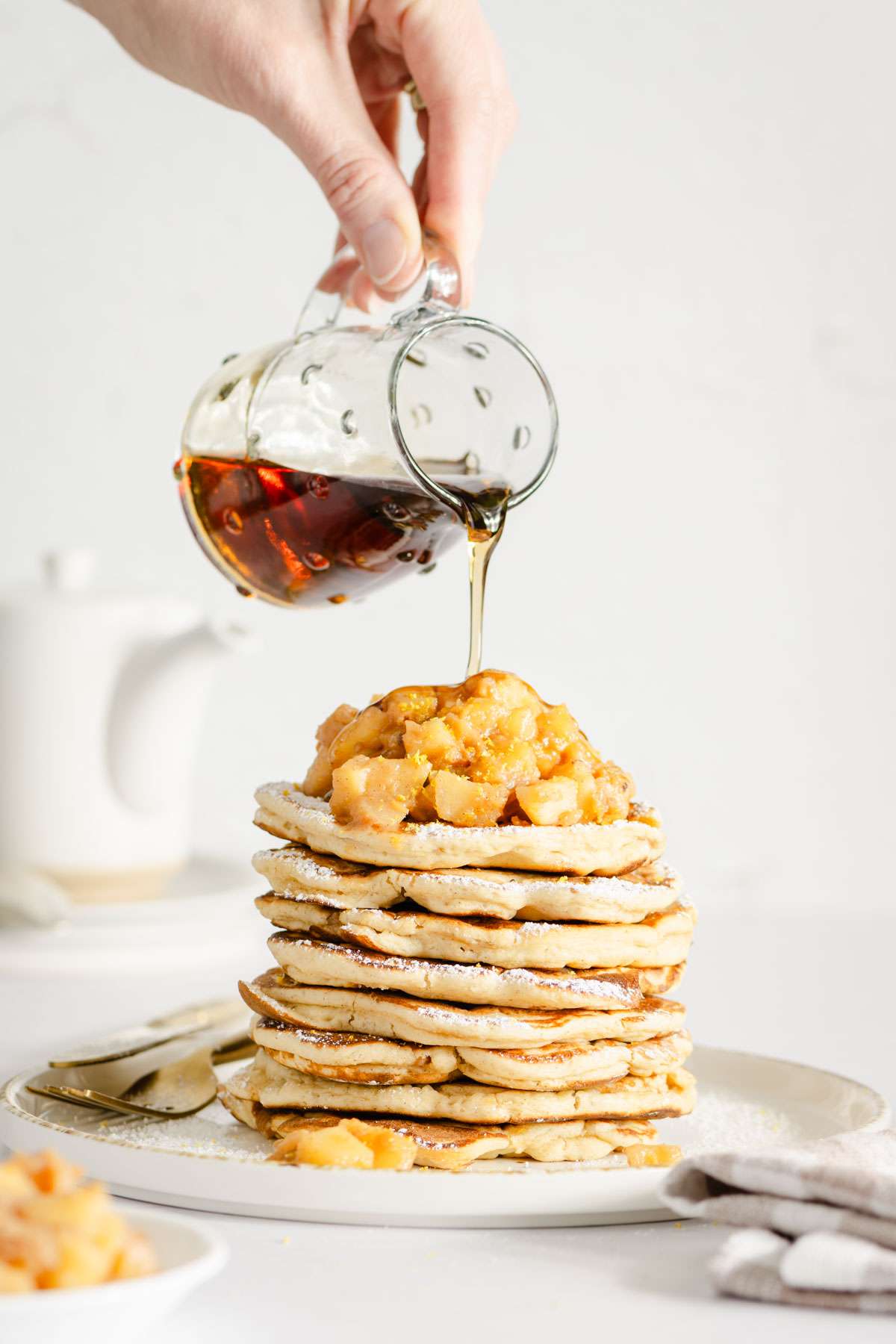 hand in frame pouring syrup over stack of racuchy