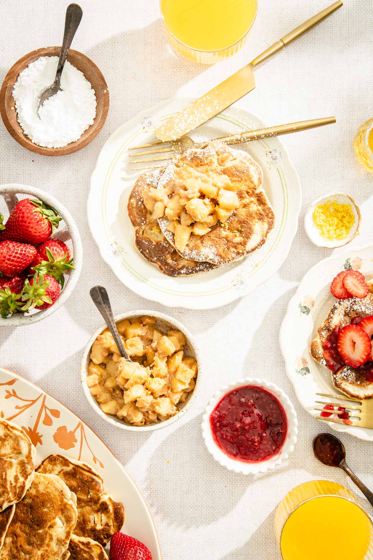 apple racuchy on a plate topped with apples, , fresh strawberries, fruit jam