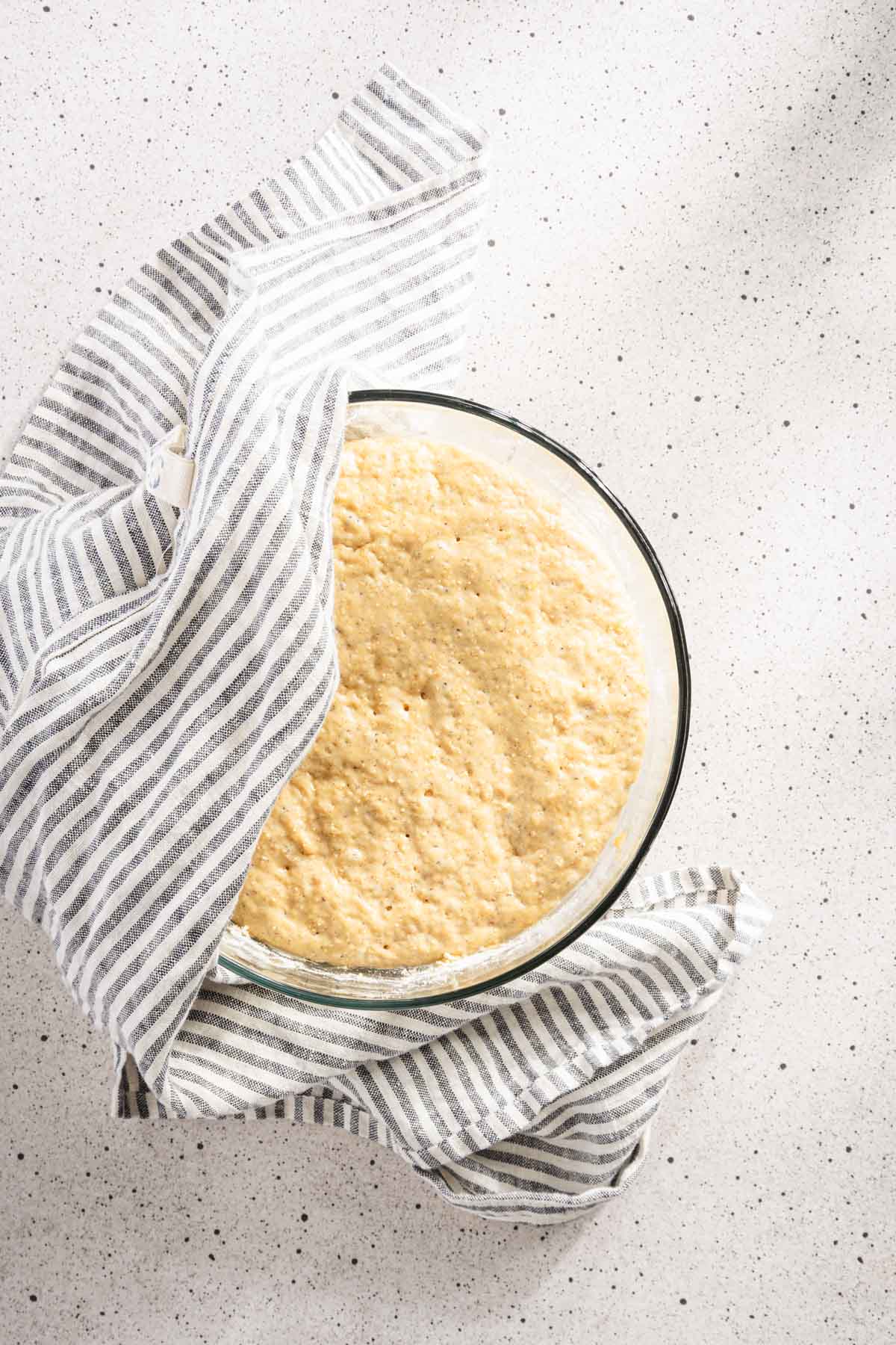 dough for Racuchy in a glass bowl, covered with a towel