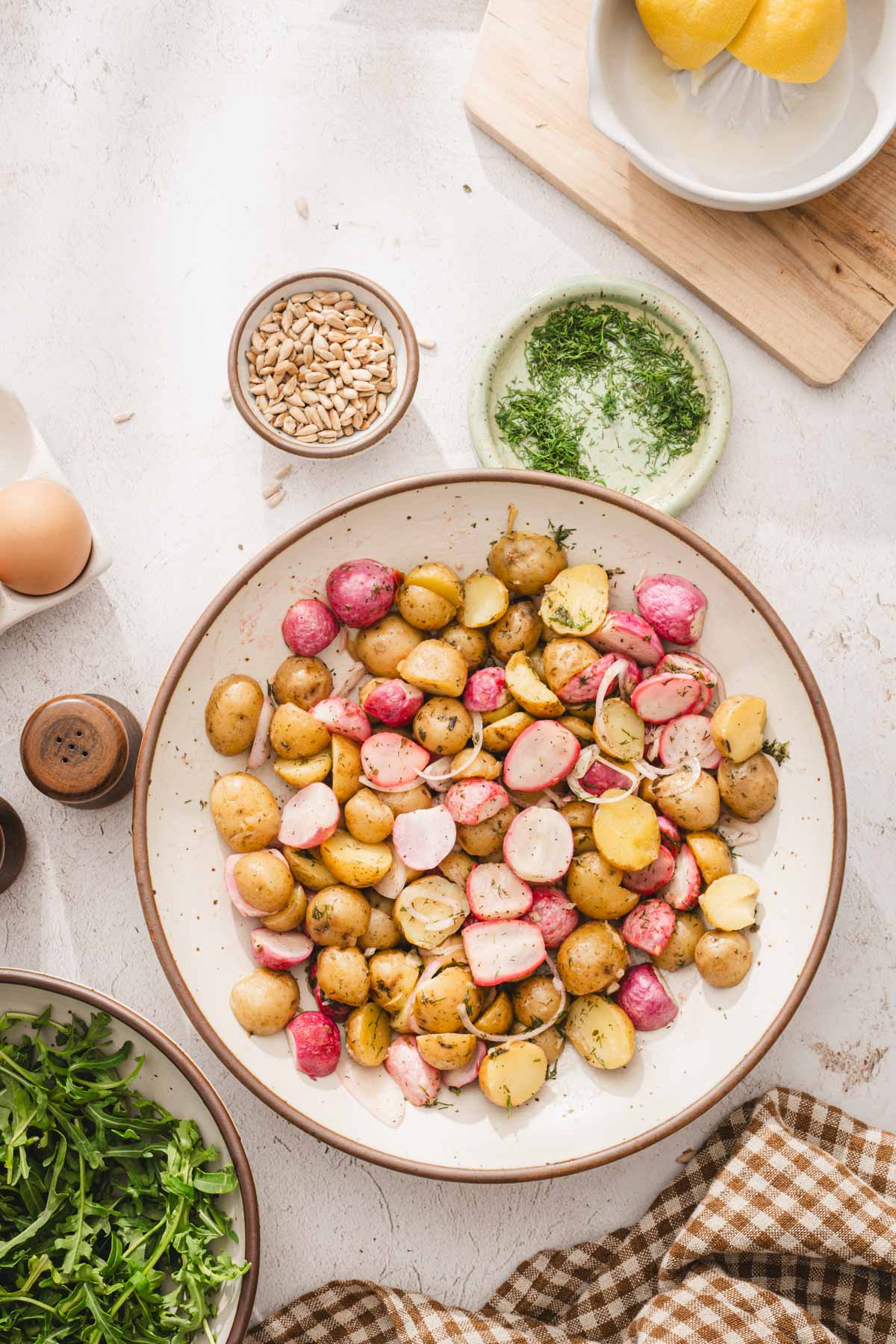 large bowl with potatos, radishes and shallots mixed in