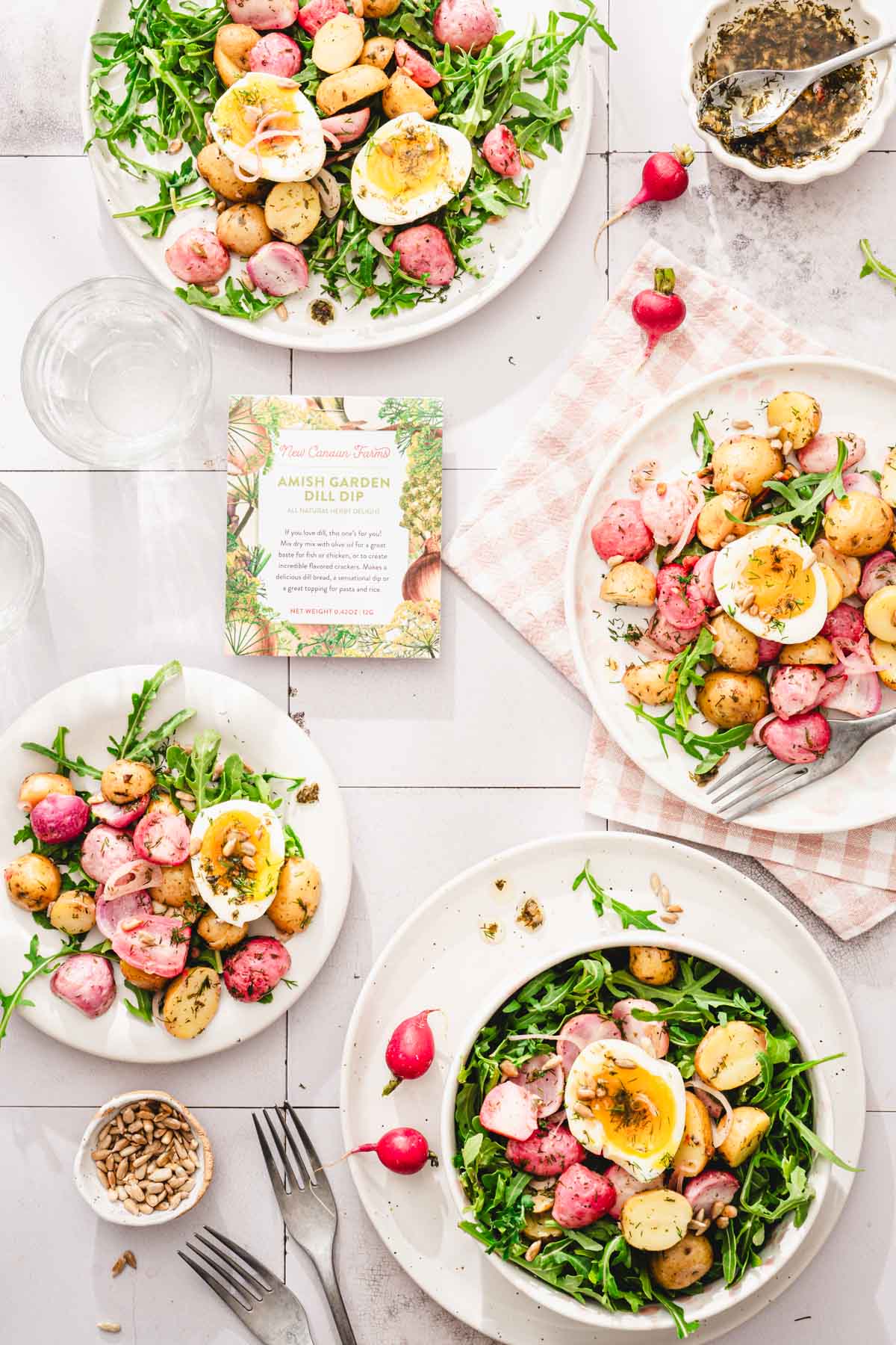 various plates with the salad, forks, dish with dressing. package with seasoning