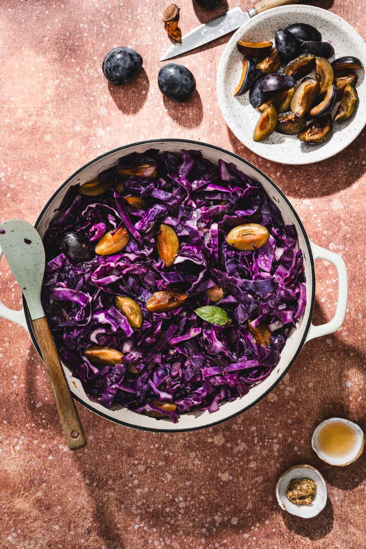 skillet with cabbage and plums