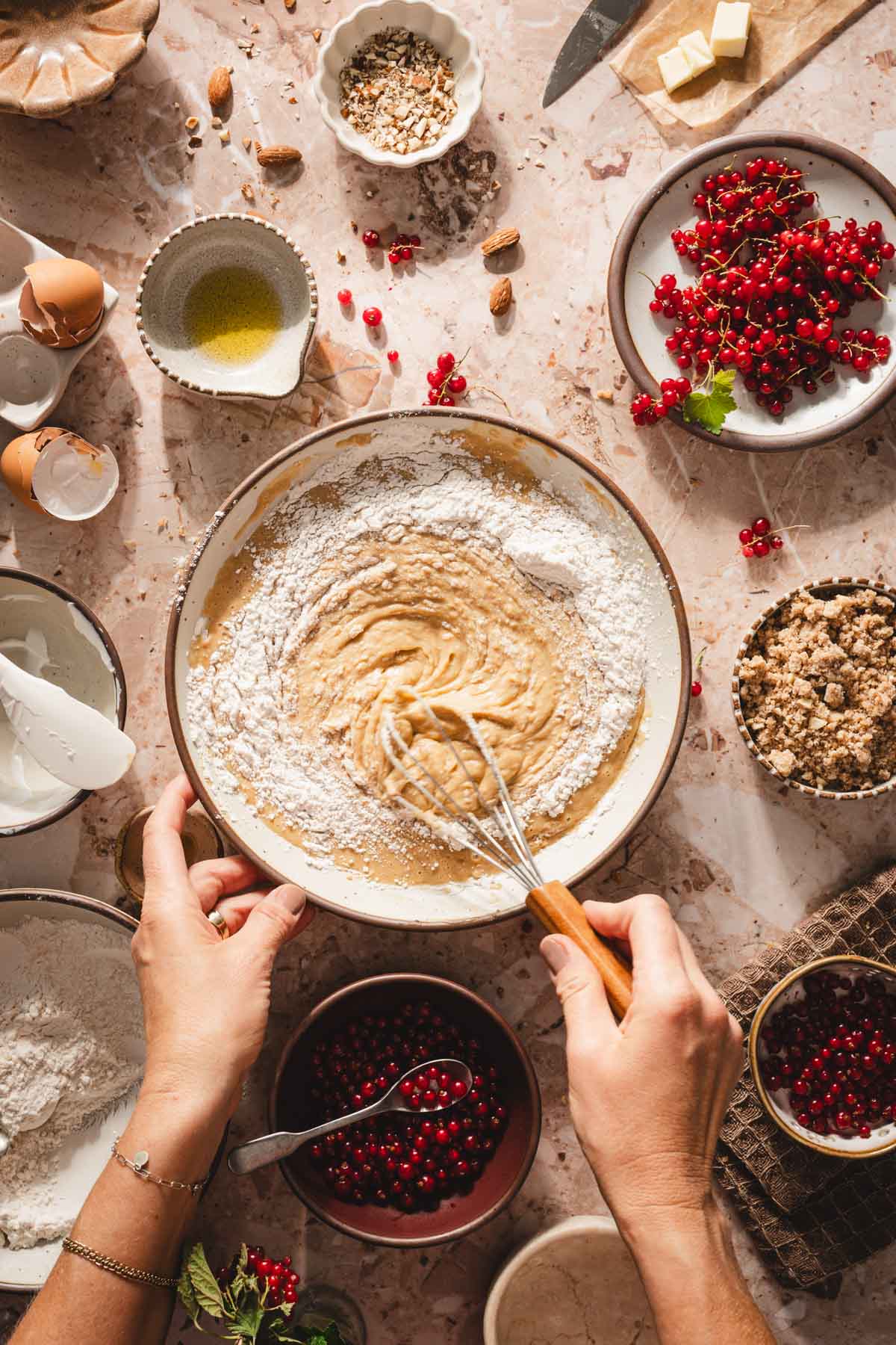 hands in frame adding flour to the wet batter