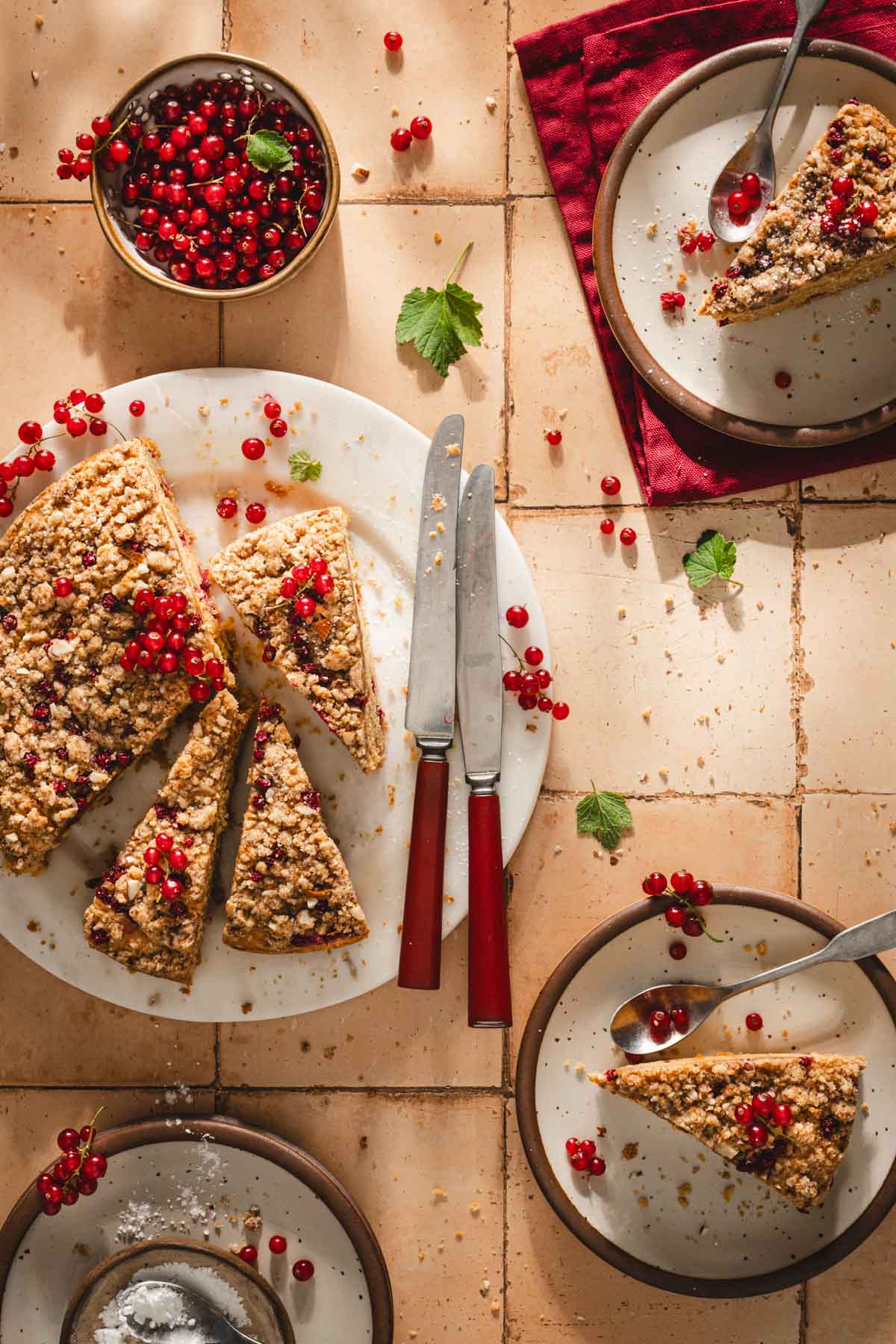 top view of sliced cake, plate with slices and bowl with berries