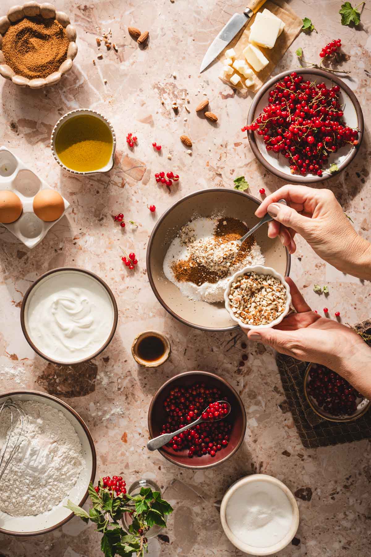 hands in frame adding almonds to a bowl