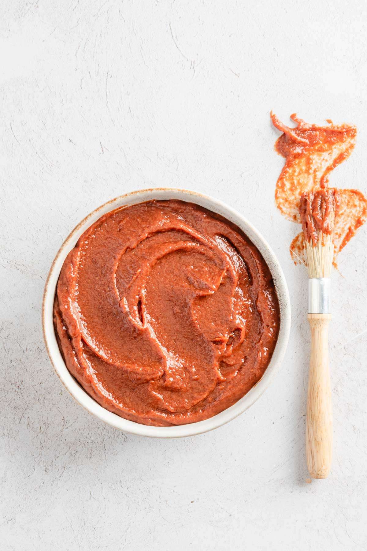 rhubarb BBQ sauce in a glass bowl, bbq brush on the side