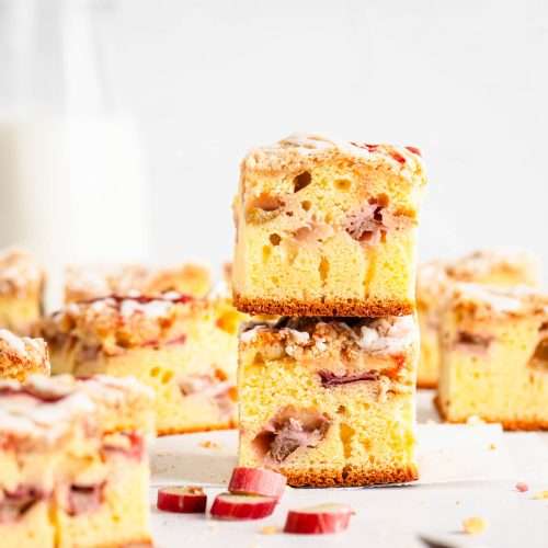 stacked rhubarb cake pieces, glass with milk