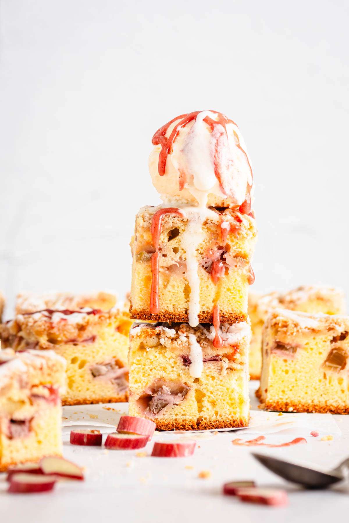 front view of rhubarb cake, slices stacked up, scoop of ice cream