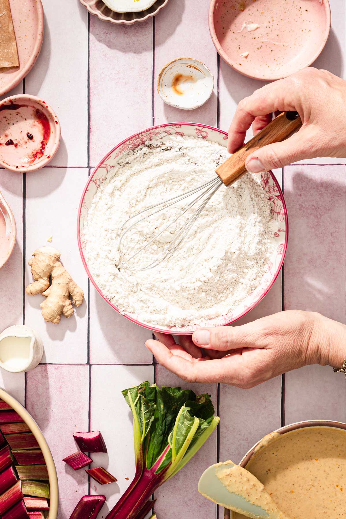 hands in frame holding whisk and mixing dry ingredients