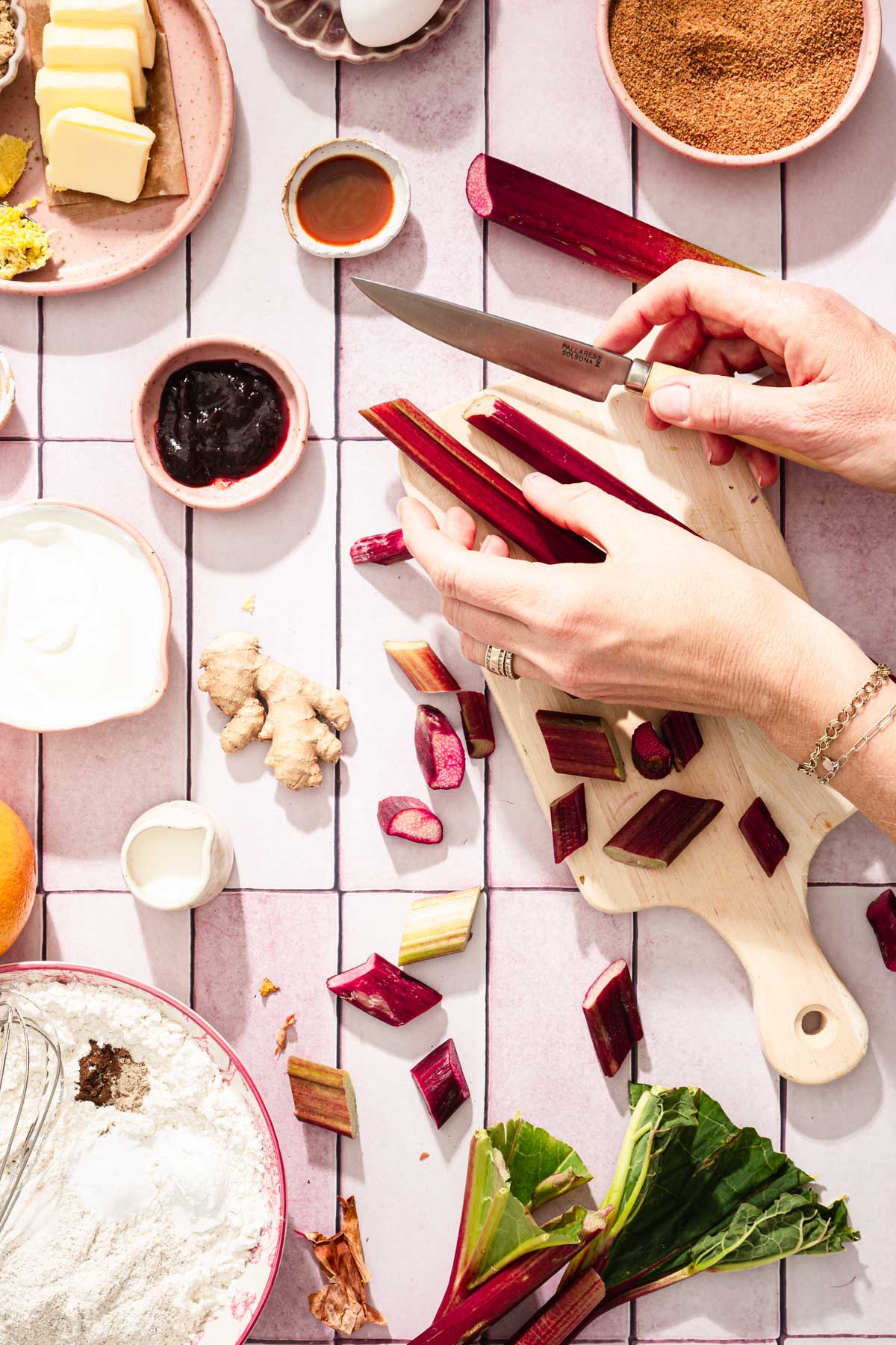 hands in frame cutting rhubarb into pieces