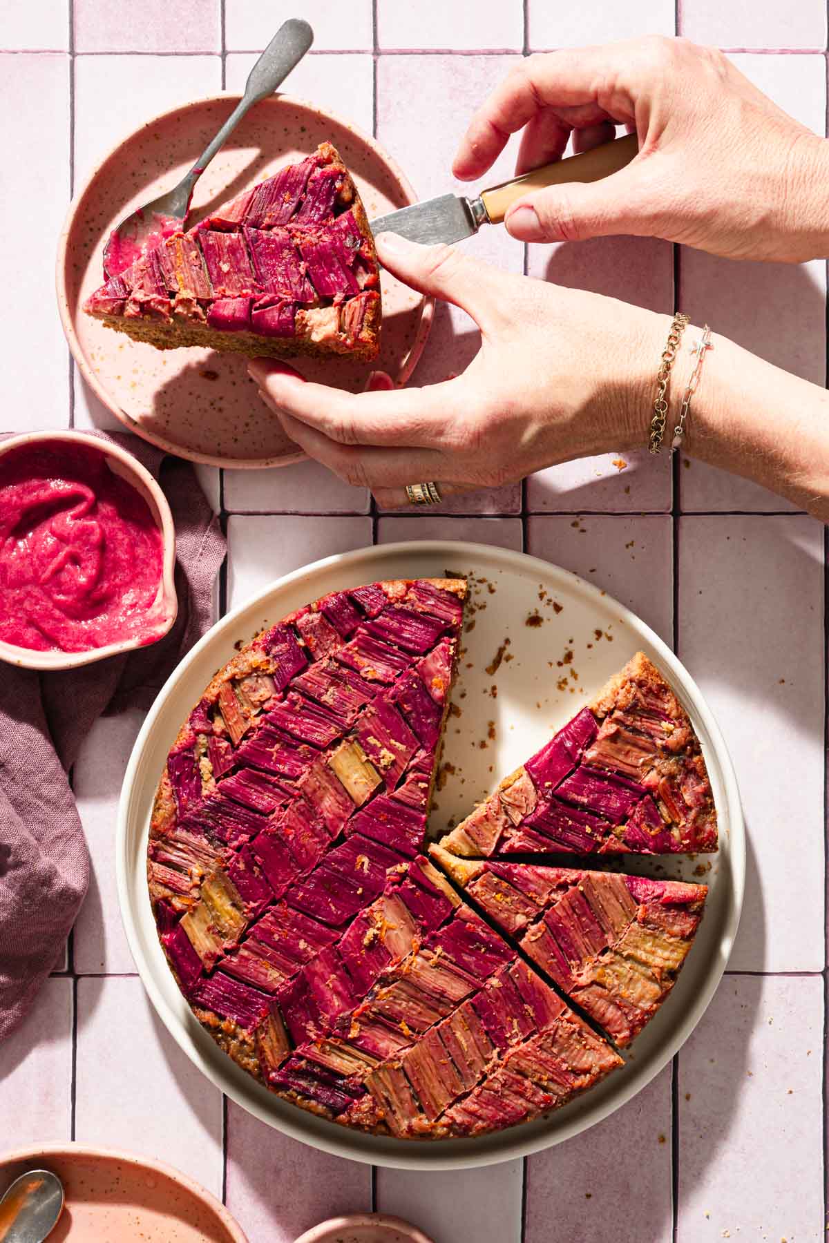 hands in frame holding piece of cake over a plate