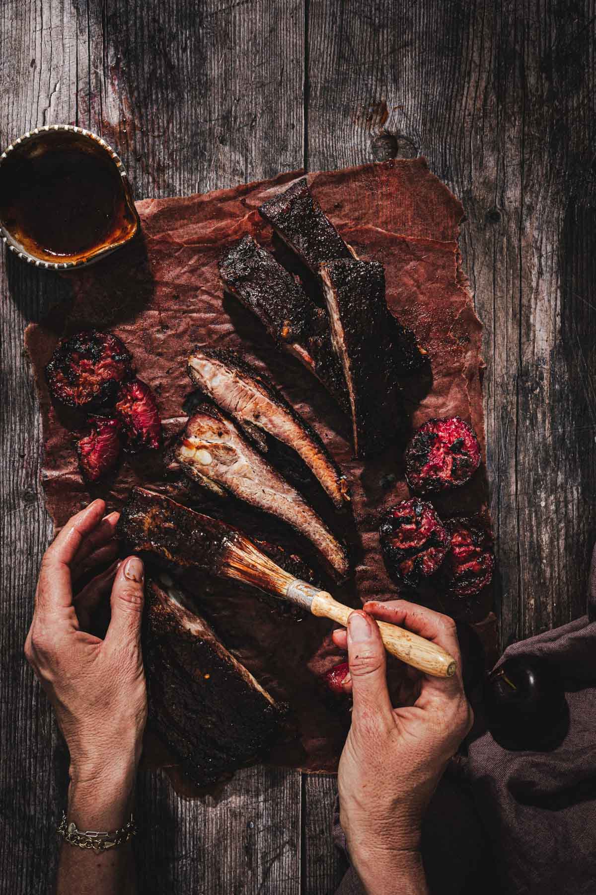 hands in frame holding a brush with bbq sauce
