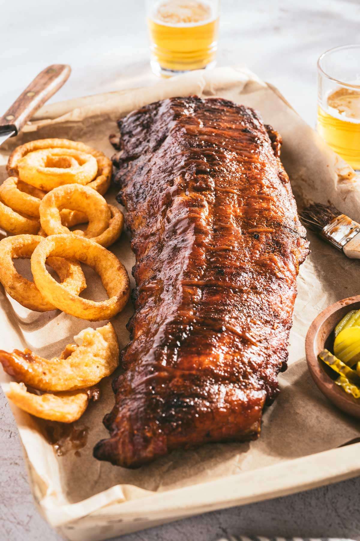 smoked ribs on a butcher paper, onion rings, pickles